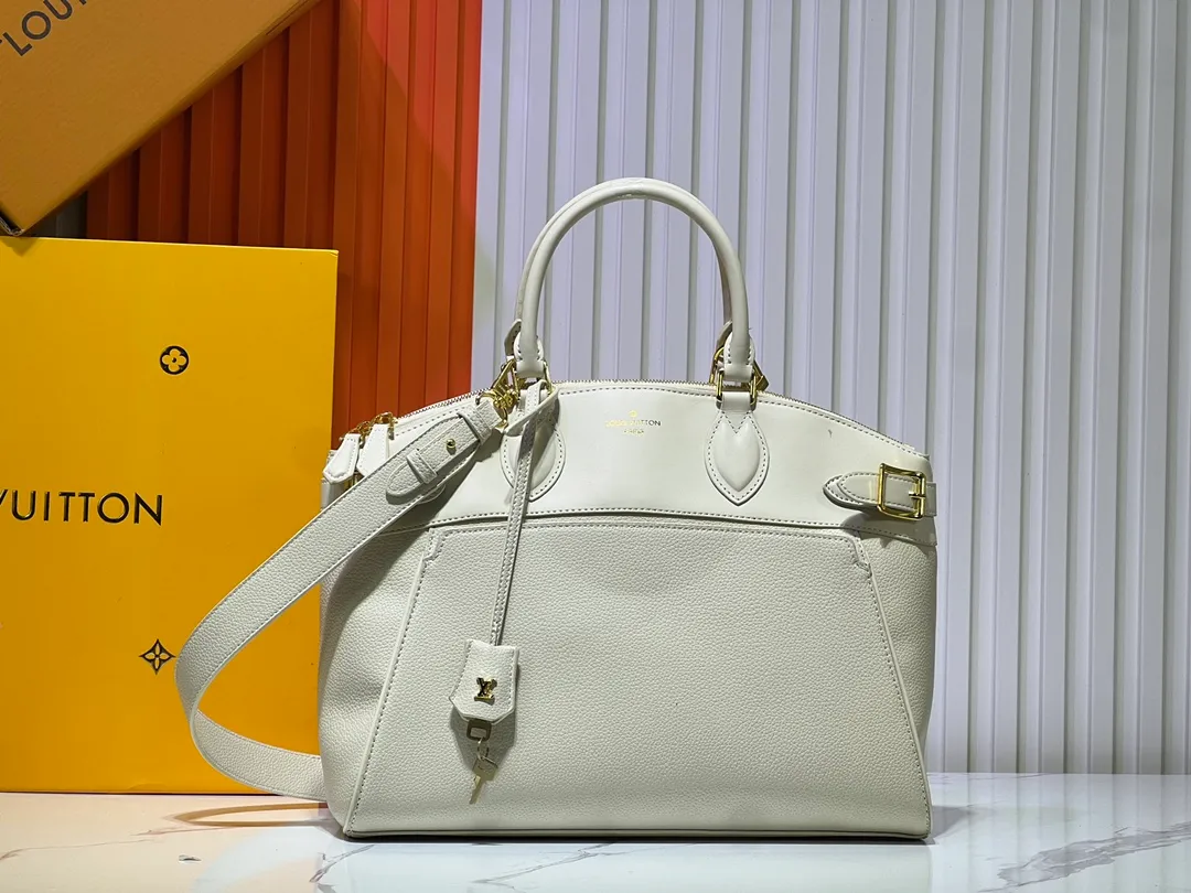Batch 340💰M11214 green M22914 black M22925 brown M23061 off-white M22927 taupe. Sophisticated and functional, the Lock It MM bag is crafted in fine grained Taurillon leather and smooth calfskin, with gold-finish buckles and hardware. Signature House touches include padlocks, key bells and hot-stamped Louis Vuitton signatures. Featuring an articulated top handle and removable strap, this tote offers a variety of carrying options. 36x29x15 cm (LxHxW) Black Taurillon leather, smooth calfskin semi-leather trim Microfiber lining Gold hardware 2 square buckles padlock key bell External pockets 2 internal flat pockets Internal zipped pocket with flat pockets 5 protective metal studs Strap: removable, adjustable Strap drop: 45.0 cm Maximum strap drop: 51.0 cm