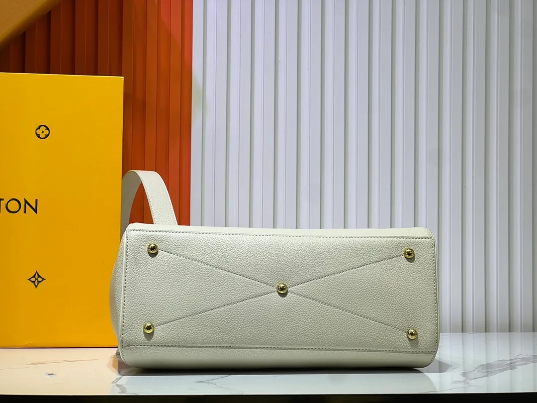 Batch 340💰M11214 green M22914 black M22925 brown M23061 off-white M22927 taupe. Sophisticated and functional, the Lock It MM bag is crafted in fine grained Taurillon leather and smooth calfskin, with gold-finish buckles and hardware. Signature House touches include padlocks, key bells and hot-stamped Louis Vuitton signatures. Featuring an articulated top handle and removable strap, this tote offers a variety of carrying options. 36x29x15 cm (LxHxW) Black Taurillon leather, smooth calfskin semi-leather trim Microfiber lining Gold hardware 2 square buckles padlock key bell External pockets 2 internal flat pockets Internal zipped pocket with flat pockets 5 protective metal studs Strap: removable, adjustable Strap drop: 45.0 cm Maximum strap drop: 51.0 cm