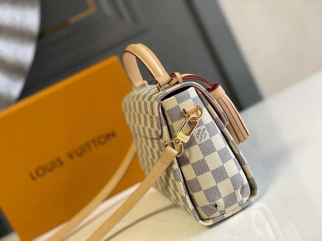 💰800 Top Original N41581 CROISETTE Handbag This small and comfortable Croisette handbag has exquisite details and complete functions, enough to become your new favorite. Removable tassels add a playful touch to the elegant design. Versatile, it can be handheld, carried on the shoulder, or carried cross-body. Detailed features 25 x 17 x 9.5 cm (Length x Height x Width) Exterior in Damier Azur coated canvas Natural cowhide leather trim Pink fabric lining Gold-tone hardware Flap and buckle closure Removable tassel in natural cowhide leather Flat inner bag Shoulder strap: removable, not adjustable Half-length strap: 56.0 cm Handle: Single handle