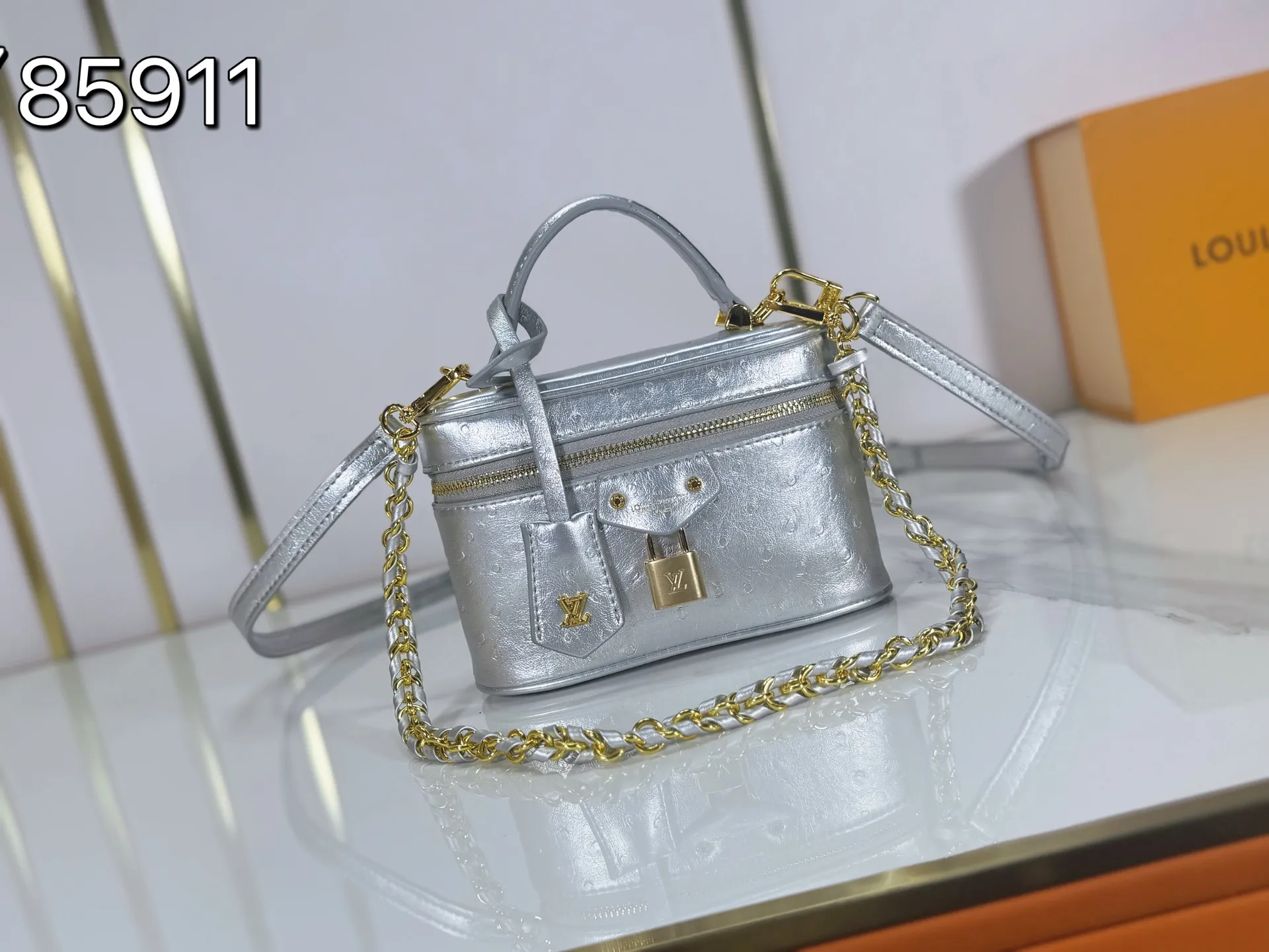 P240 M85911 M85820 M47125 Ostrich leather Vanity Chain Pouch cosmetic box chain bag is inspired by traditional cosmetic boxes and embodies the spirit of travel. This refined, slim bag is trimmed with goatskin trim on the top handle and features a removable braided chain. It is known for its rich collection of iconic details, including LV engraved padlocks and ostrich leather key bells. size：19x11x.5x6.5cm