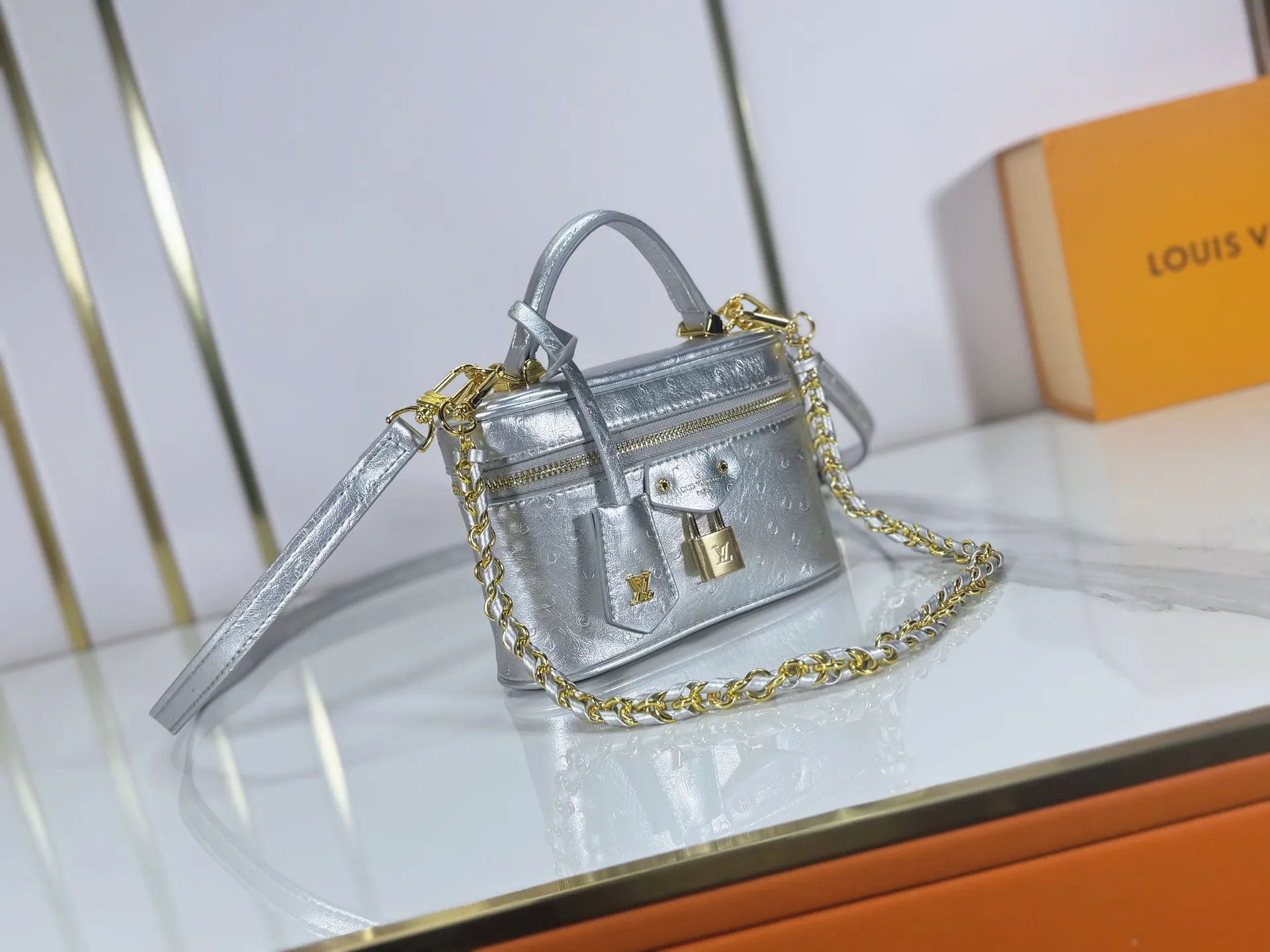 P240 M85911 M85820 M47125 Ostrich leather Vanity Chain Pouch cosmetic box chain bag is inspired by traditional cosmetic boxes and embodies the spirit of travel. This refined, slim bag is trimmed with goatskin trim on the top handle and features a removable braided chain. It is known for its rich collection of iconic details, including LV engraved padlocks and ostrich leather key bells. size：19x11x.5x6.5cm