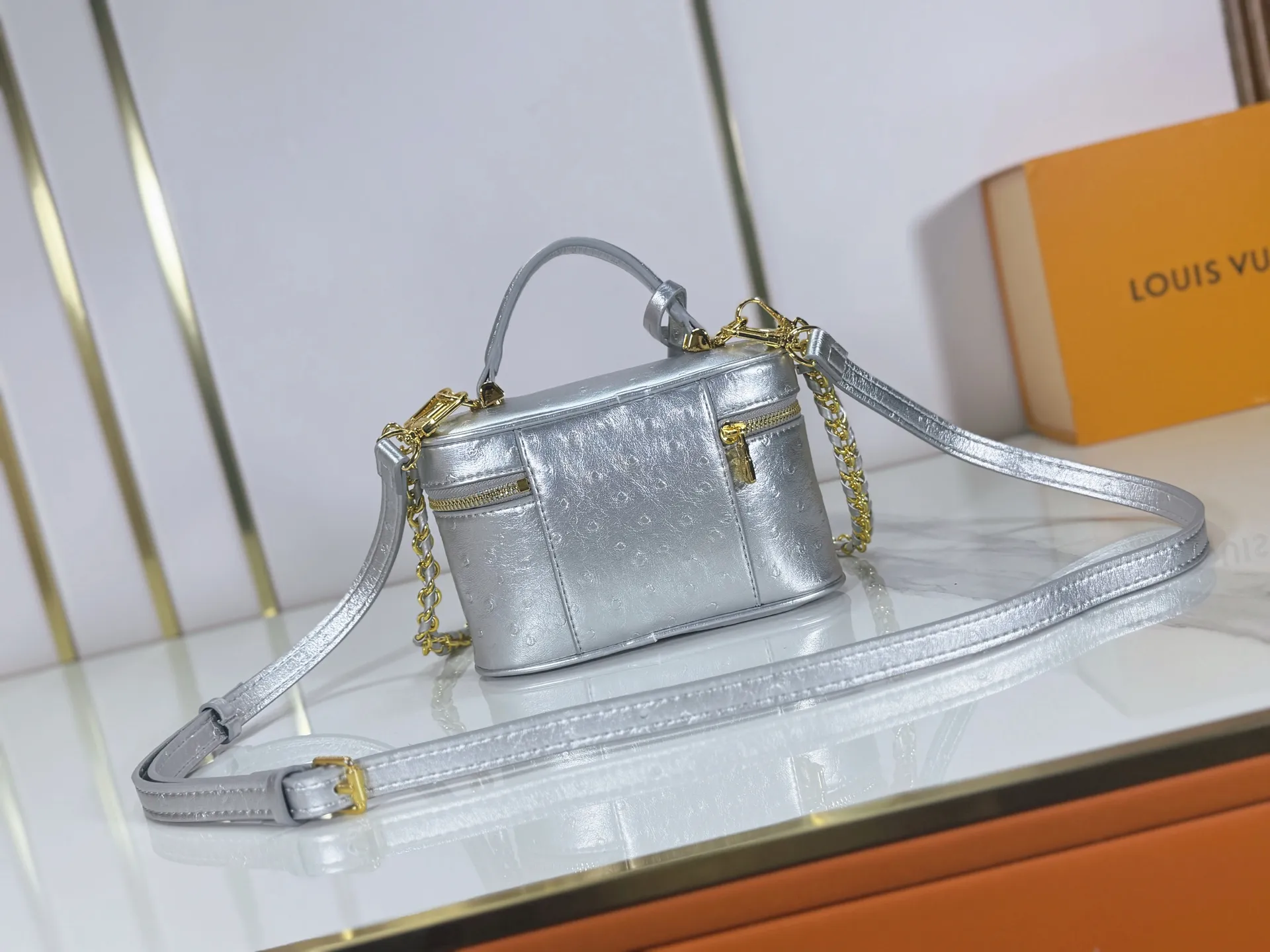P240 M85911 M85820 M47125 Ostrich leather Vanity Chain Pouch cosmetic box chain bag is inspired by traditional cosmetic boxes and embodies the spirit of travel. This refined, slim bag is trimmed with goatskin trim on the top handle and features a removable braided chain. It is known for its rich collection of iconic details, including LV engraved padlocks and ostrich leather key bells. size：19x11x.5x6.5cm