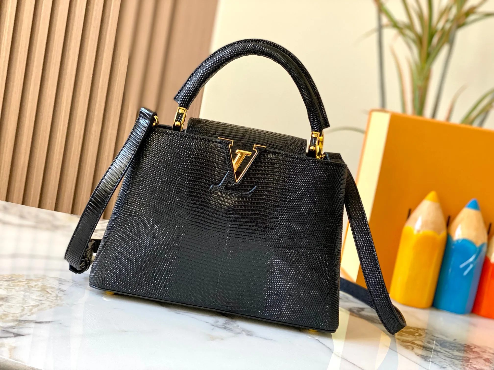 Top original P440 Guangzhou-made M99528 black lizard skin gold buckle CapucinesBB handbag exquisitely combines graceful lizard skin outer layer, delicate sheepskin lining and glossy metal parts. The iconic flap makes two styles fashionable. The LV logo is read on the inside and Monogram flowers bloom on the outside. It lights up an eye-catching corner for evening occasions and adds a personalized atmosphere to the wardrobe. Shine gorgeous style in day and night occasions.  Detailed features 27 x 18 x 9 cm (length x height x width)