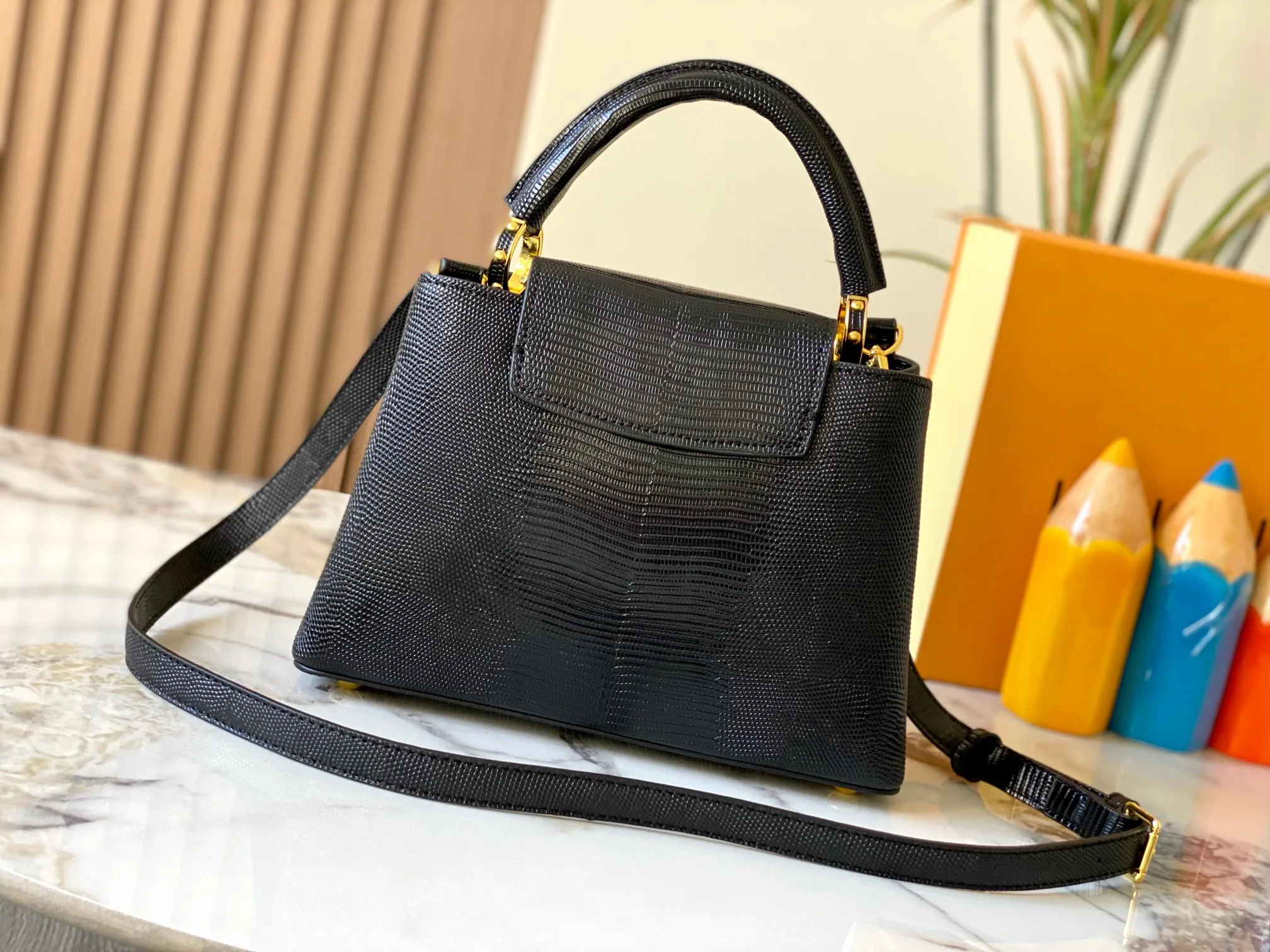 Top original P440 Guangzhou-made M99528 black lizard skin gold buckle CapucinesBB handbag exquisitely combines graceful lizard skin outer layer, delicate sheepskin lining and glossy metal parts. The iconic flap makes two styles fashionable. The LV logo is read on the inside and Monogram flowers bloom on the outside. It lights up an eye-catching corner for evening occasions and adds a personalized atmosphere to the wardrobe. Shine gorgeous style in day and night occasions.  Detailed features 27 x 18 x 9 cm (length x height x width)