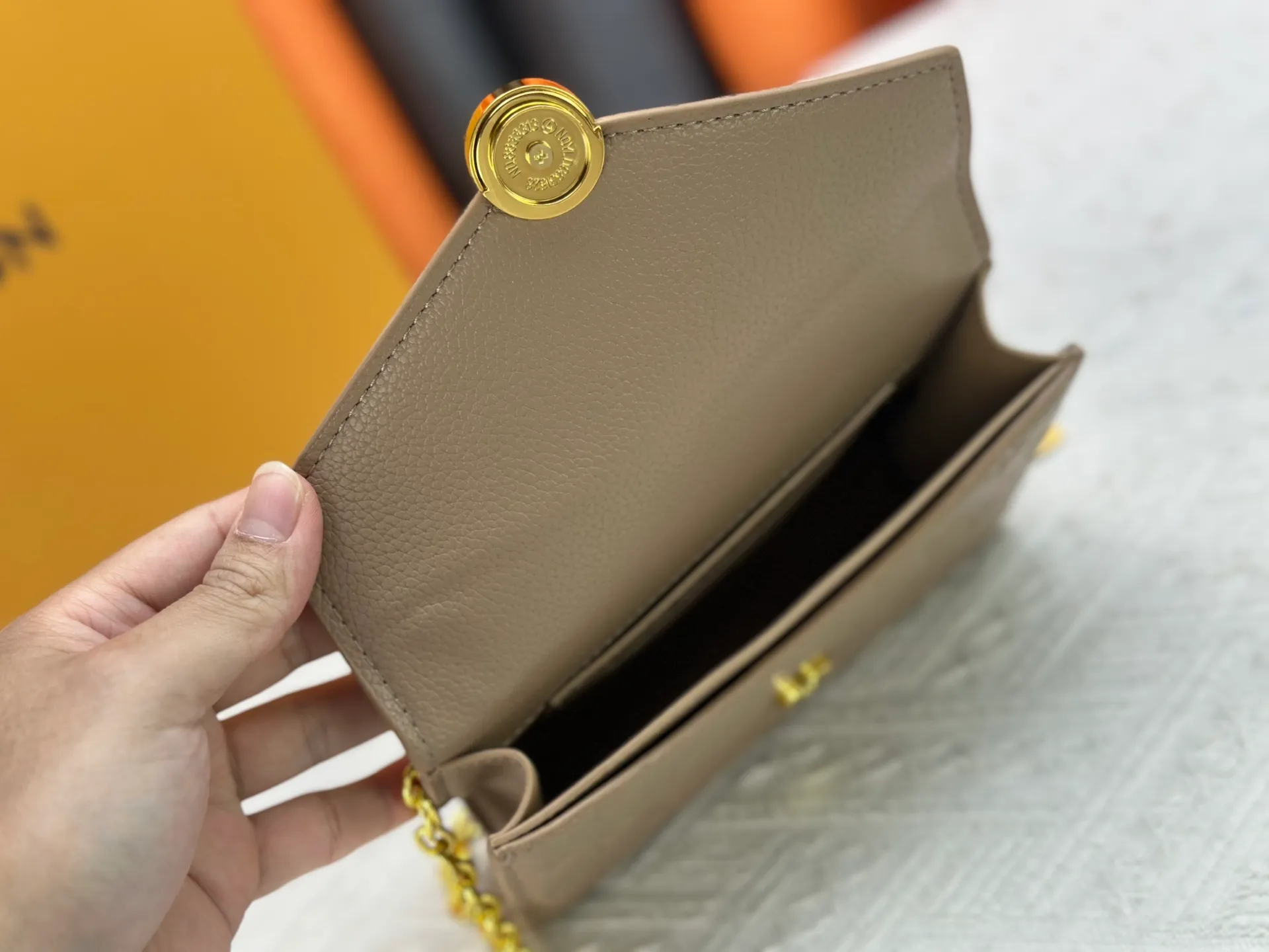P220 M13569 black M13570 gray M25814 burgundy (chain/embossed) [Portefeuille chaîne Rosy] This Rosy chain wallet is both fashionable and practical, adding a modern spirit to the Monogram Empreinte series. It has an elegant LV circle and a V-shaped flap, two hallmarks of the house. The magnetic closure reveals a surprise Monogram flower, as well as three card slots and a flat interior pocket. The sliding chain allows you to wear it crosswise or over the shoulder.  Dimensions: 19.5 x 13.5 x 6.5 cm
