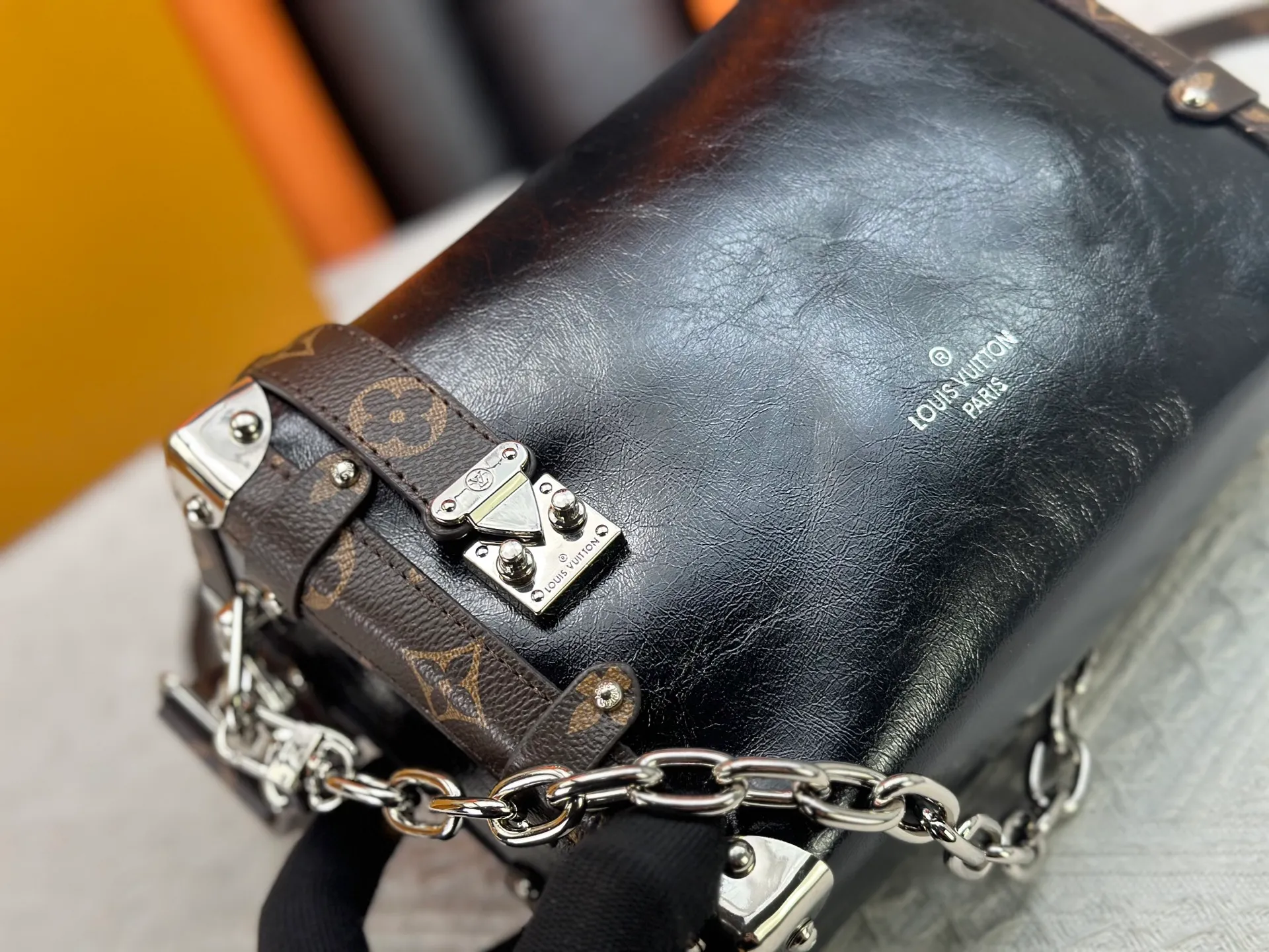 P300 M15195 M46358 This Side Trunk Vibe handbag reimagines the brand's classic Side Trunk silhouette with an avant-garde design, inspired by Louis Vuitton's traditional travel trunks. Crafted from smooth glossy Vibe textured cow leather, it features a leather-covered rivet frame and metal S-lock closure for a rock-and-roll style. Thanks to the multiple designs of the detachable chain, detachable leather handle and adjustable leather shoulder strap, it provides a variety of carrying options. Dimensions: 23.5x16x8.5cm