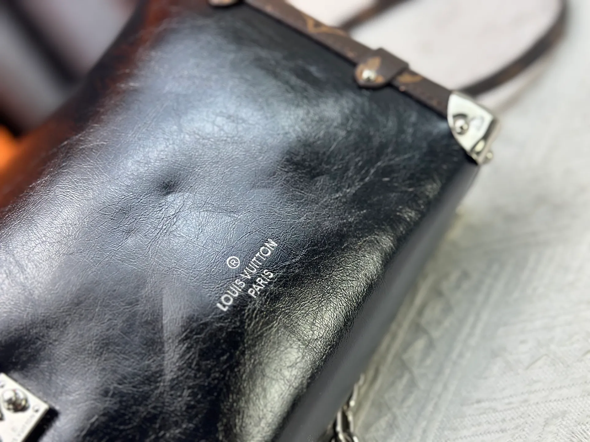 P300 M15195 M46358 This Side Trunk Vibe handbag reimagines the brand's classic Side Trunk silhouette with an avant-garde design, inspired by Louis Vuitton's traditional travel trunks. Crafted from smooth glossy Vibe textured cow leather, it features a leather-covered rivet frame and metal S-lock closure for a rock-and-roll style. Thanks to the multiple designs of the detachable chain, detachable leather handle and adjustable leather shoulder strap, it provides a variety of carrying options. Dimensions: 23.5x16x8.5cm