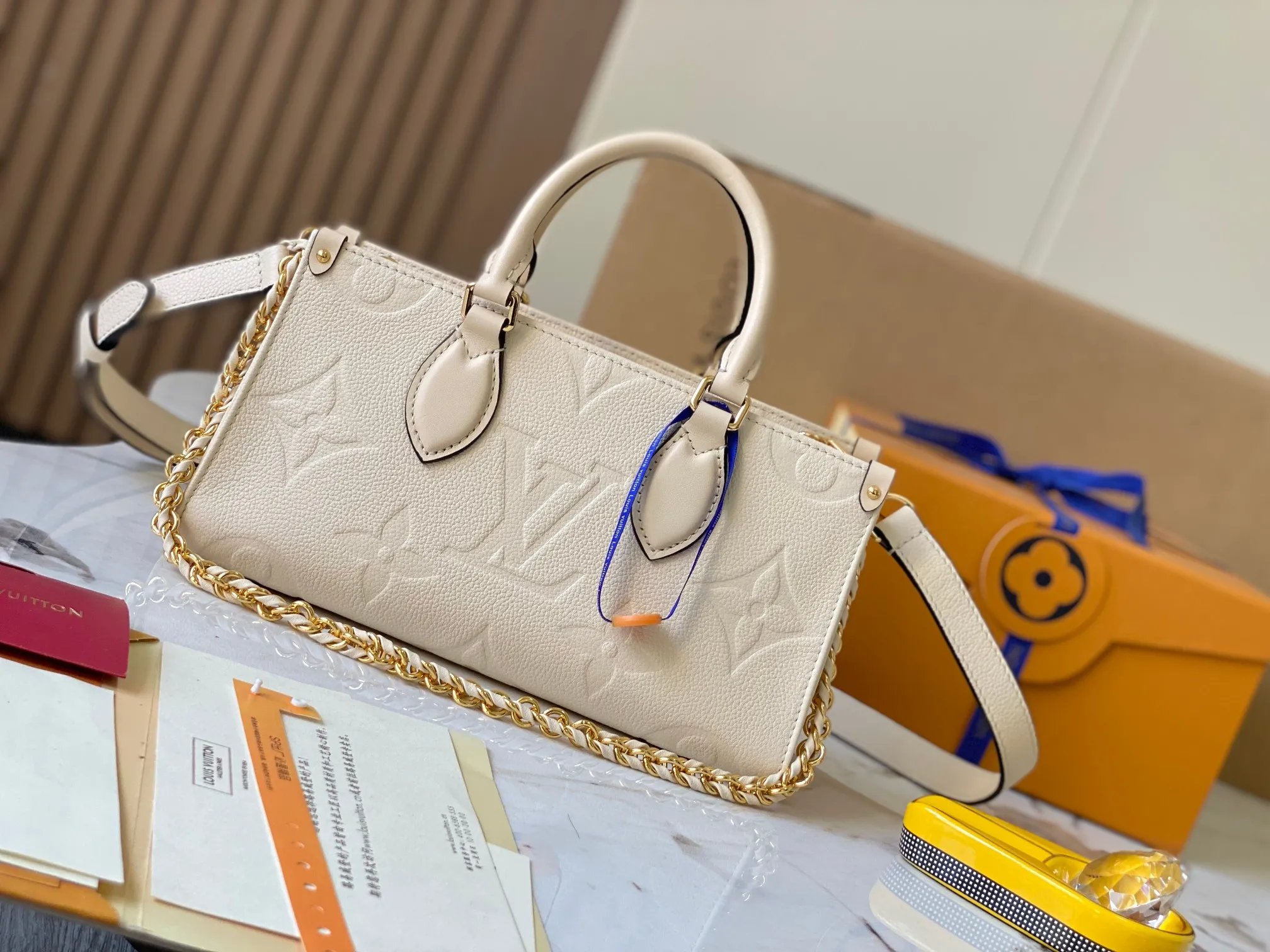 P1440 [Original leather 💋 M23698 milk white] [OnTheGo East West handbag] Introducing the design of Ays OnTheGo small tote bag, using Monogram Empreinte leather to reinterpret the ample configuration of East West. The Giant Monogram is embossed on the leather body, and the neat interior can store daily necessities. The top handle and removable leather chain strap allow for multiple carry options.  Dimensions: 25.0 x 13.0 x 10.0 cmP