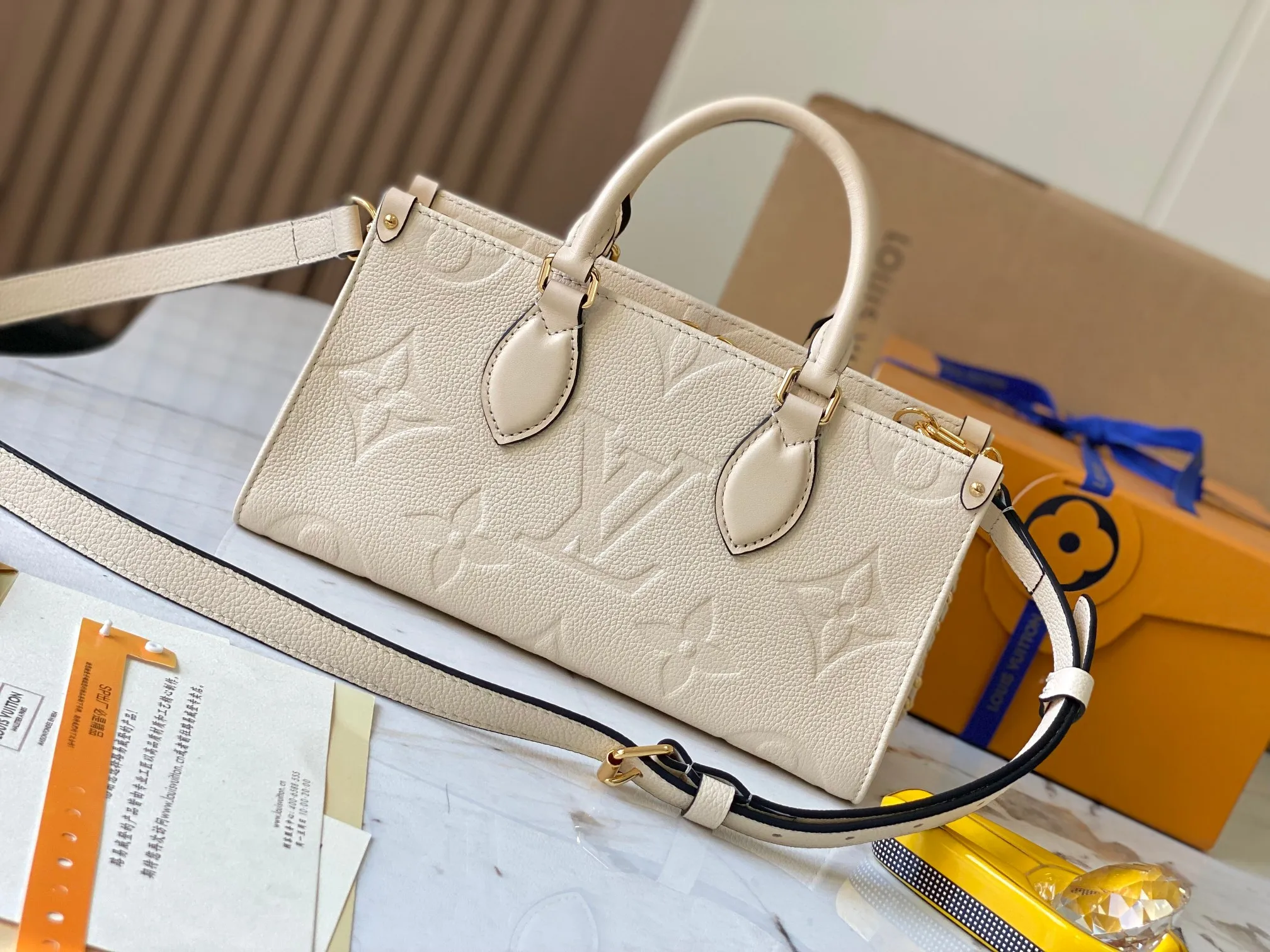 P1440 [Original leather 💋 M23698 milk white] [OnTheGo East West handbag] Introducing the design of Ays OnTheGo small tote bag, using Monogram Empreinte leather to reinterpret the ample configuration of East West. The Giant Monogram is embossed on the leather body, and the neat interior can store daily necessities. The top handle and removable leather chain strap allow for multiple carry options.  Dimensions: 25.0 x 13.0 x 10.0 cmP