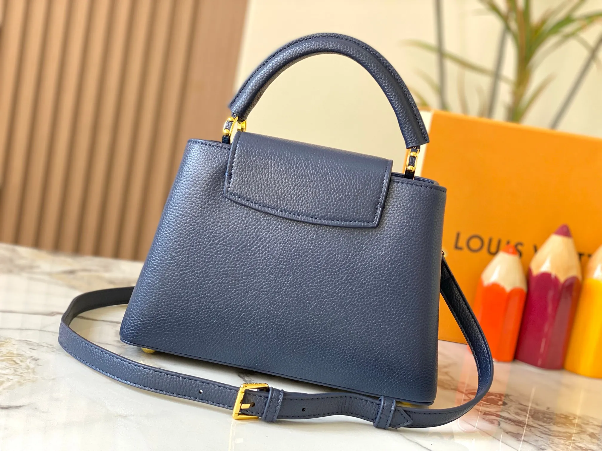 P500 [Guangzhou top quality original version] M26532 Blue This modern version of Capucines BB is made of timeless Taurillon leather and equipped with a jewelry-inspired Infinity chain. The bag is decorated with double galvanized metal parts, including the iconic Monogram floral pattern, and the LV Initials logo created with sunburst technology, creating a sundial-like light and shadow effect. The bag has multiple pockets and a detachable shoulder strap, allowing it to be carried on one shoulder or across the body. 27 x 17.3 x 9 (cm) (length x height x width)