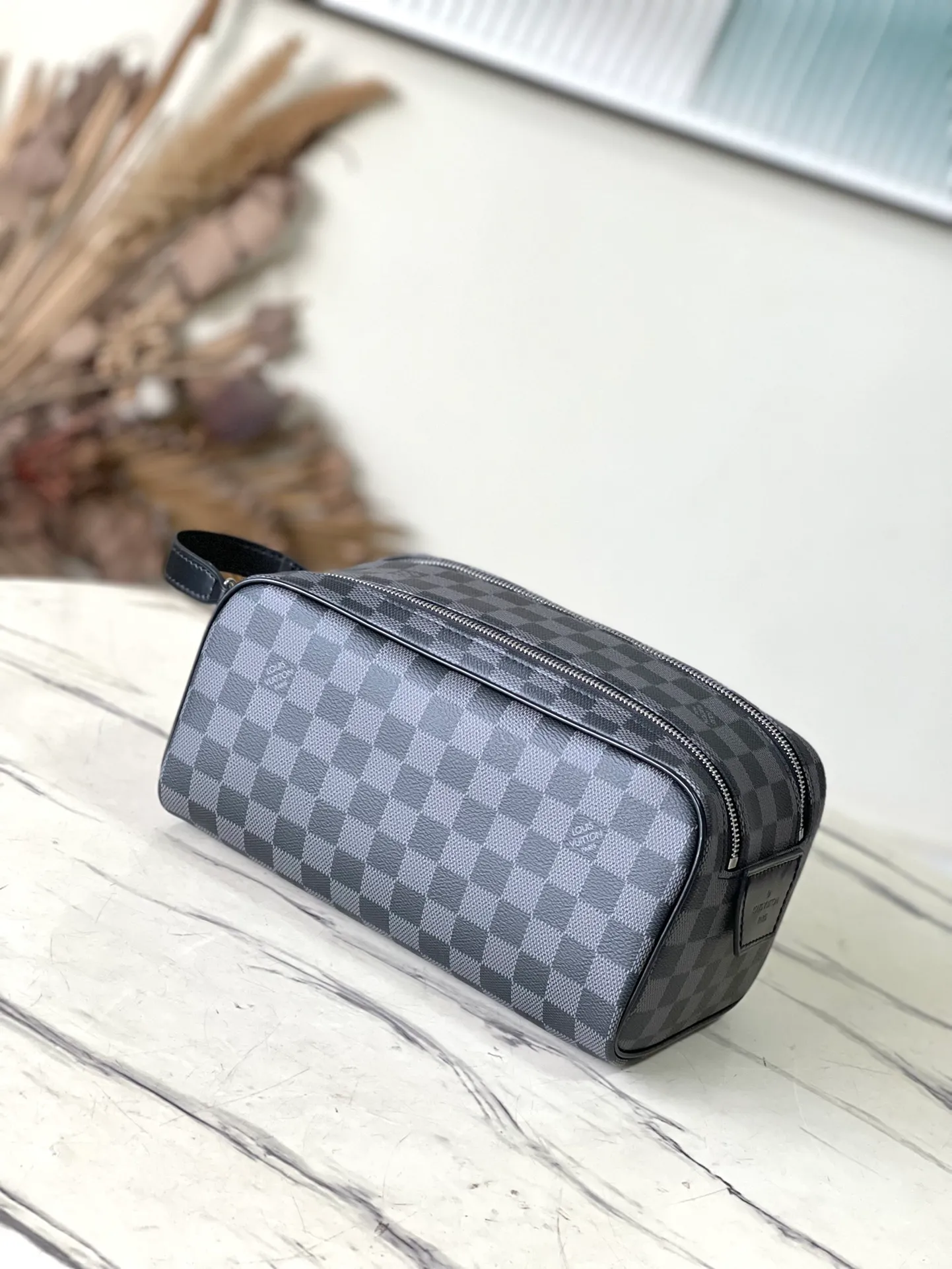 💰660 Top Original N40127 Black Dopp Washing Bag is made of classic Damier Graphite canvas and cow leather trim and has a hard design. Double zippers hide ample internal space for easy access to washing and combing tools. The wide handle makes it comfortable to carry or hang on a bathroom hook. Dimensions: 28 × 15 × 16.5 cm