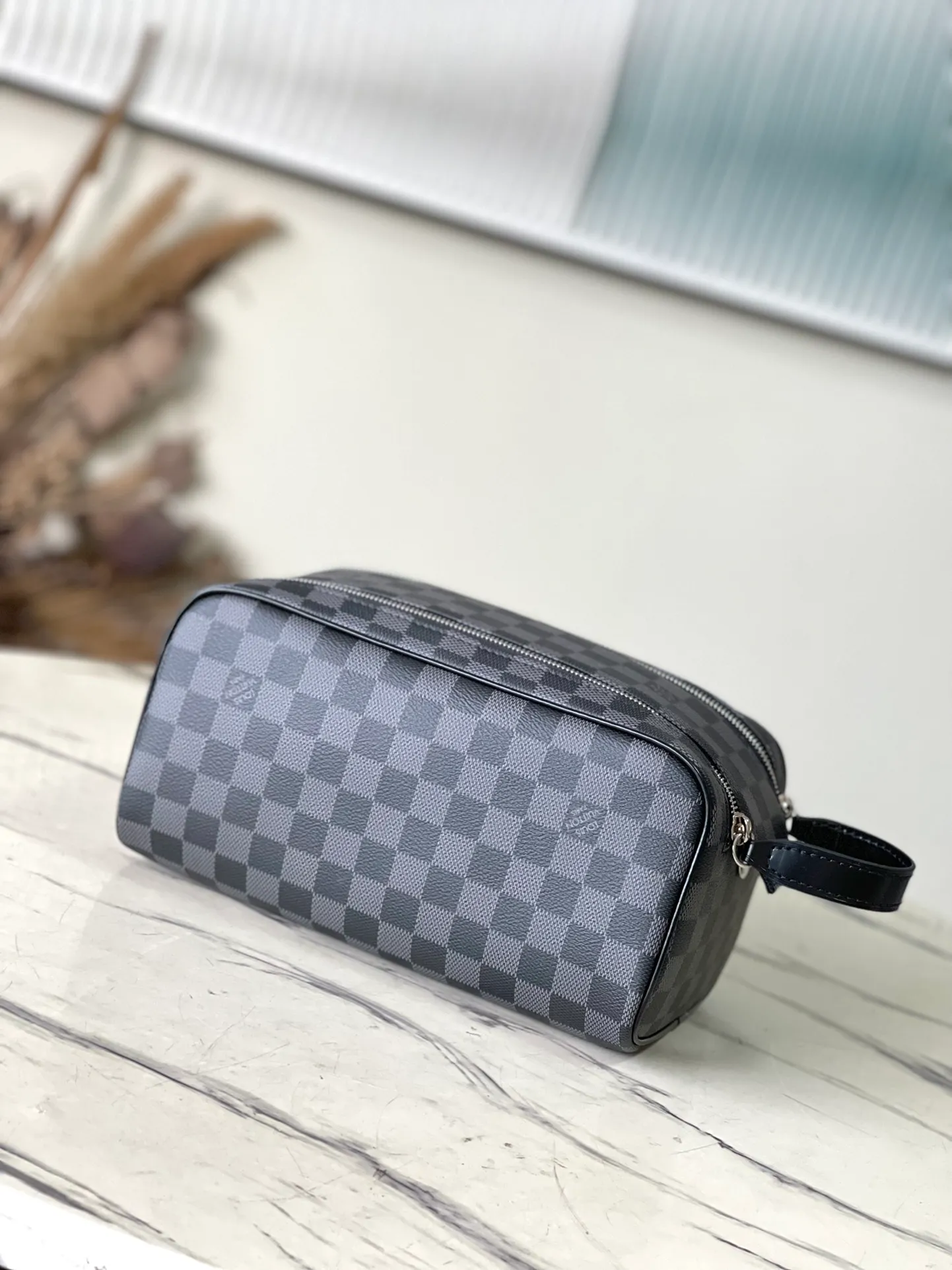 💰660 Top Original N40127 Black Dopp Washing Bag is made of classic Damier Graphite canvas and cow leather trim and has a hard design. Double zippers hide ample internal space for easy access to washing and combing tools. The wide handle makes it comfortable to carry or hang on a bathroom hook. Dimensions: 28 × 15 × 16.5 cm