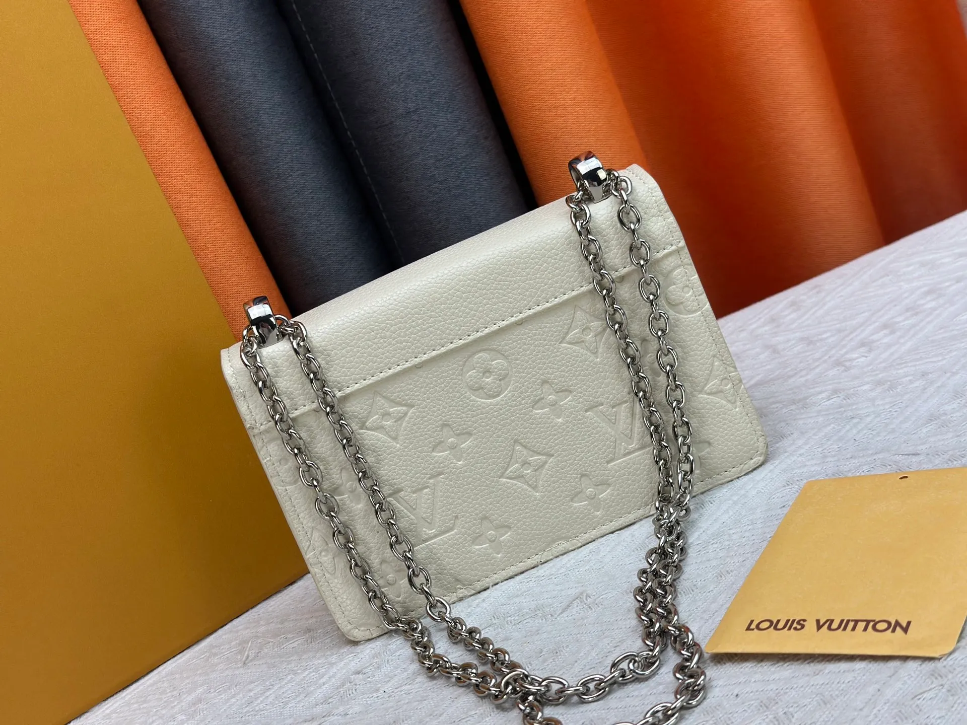 P220 M13569 black M13570 gray M25814 burgundy (chain/embossed) [Portefeuille chaîne Rosy] This Rosy chain wallet is both fashionable and practical, adding a modern spirit to the Monogram Empreinte series. It has an elegant LV circle and a V-shaped flap, two hallmarks of the house. The magnetic closure reveals a surprise Monogram flower, as well as three card slots and a flat interior pocket. The sliding chain allows you to wear it crosswise or over the shoulder.  Dimensions: 19.5 x 13.5 x 6.5 cm