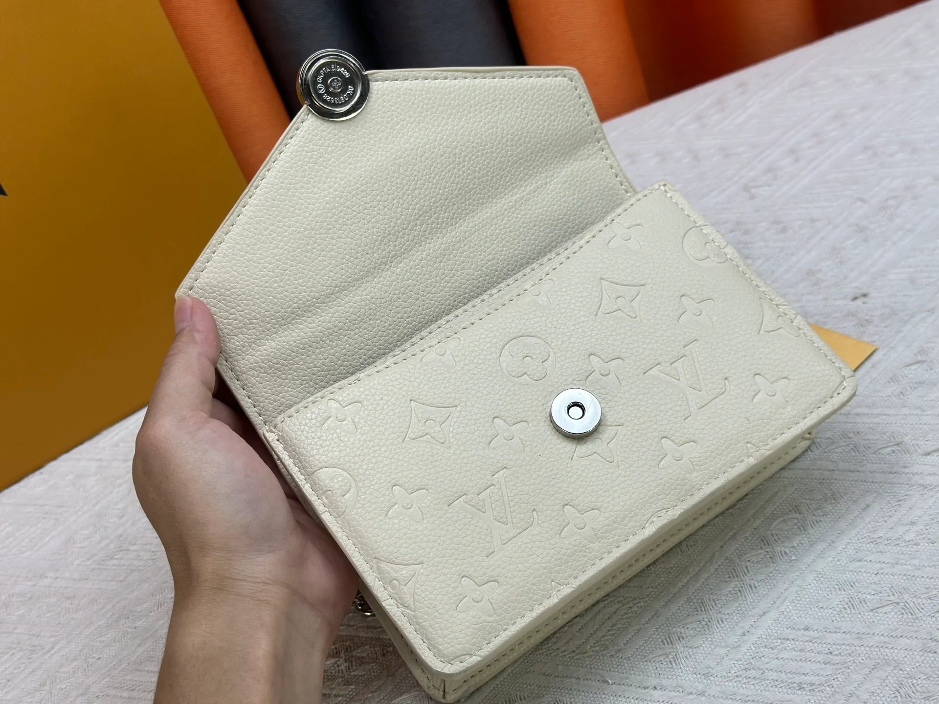 P220 M13569 black M13570 gray M25814 burgundy (chain/embossed) [Portefeuille chaîne Rosy] This Rosy chain wallet is both fashionable and practical, adding a modern spirit to the Monogram Empreinte series. It has an elegant LV circle and a V-shaped flap, two hallmarks of the house. The magnetic closure reveals a surprise Monogram flower, as well as three card slots and a flat interior pocket. The sliding chain allows you to wear it crosswise or over the shoulder.  Dimensions: 19.5 x 13.5 x 6.5 cm
