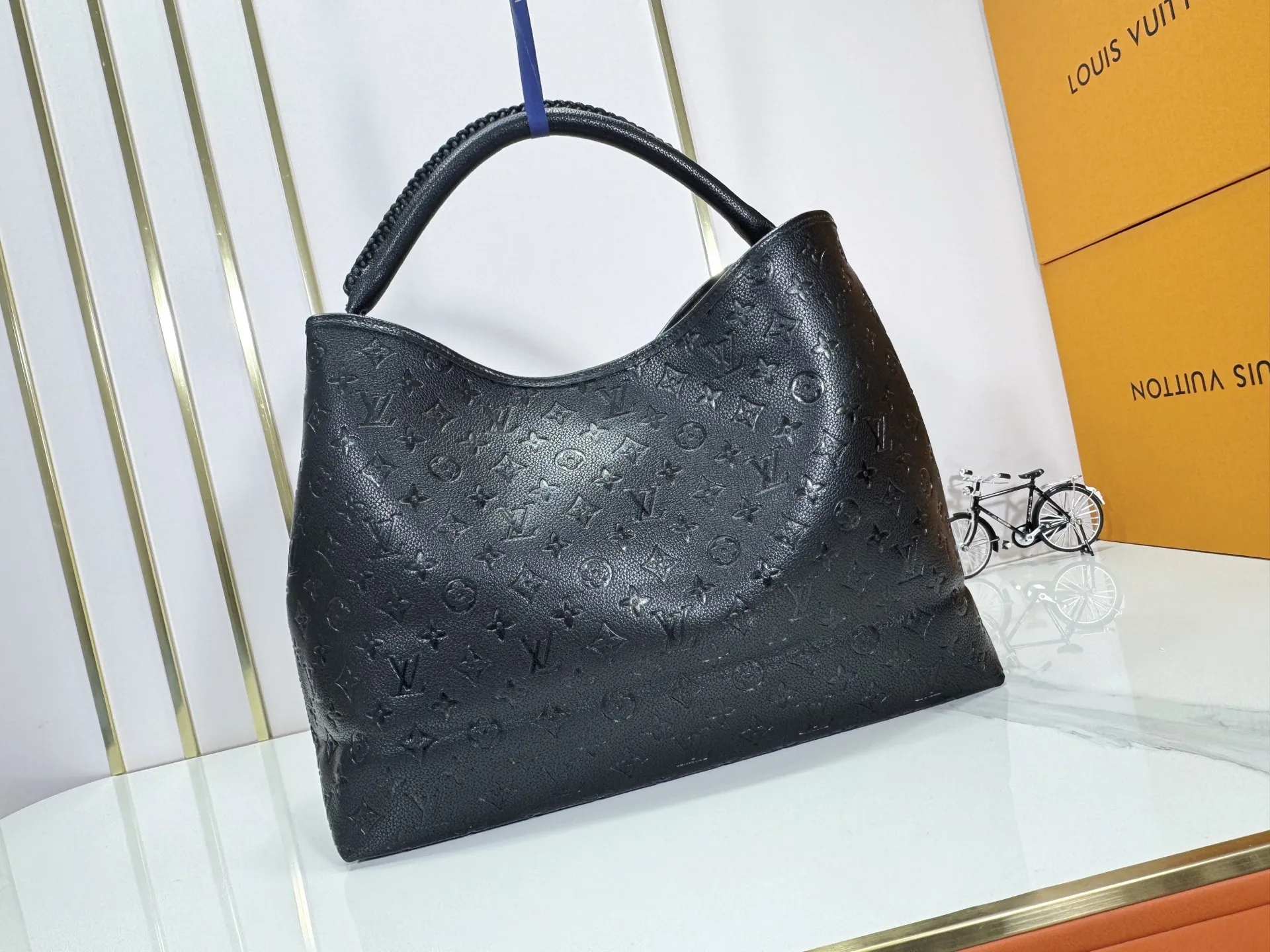 P280 upgrades the original M25877 Again handbag, a new interpretation of the iconic Artsy design first launched in 2010, now more flexible, more iconic and more refined. Rooted in LV’s DNA, this bag pays homage to Louis Vuitton’s craftsmanship with its classic Monogram canvas base, hand-woven handles and customizable name tag. It's spacious enough to hold a laptop and opens to reveal multiple pockets. Gold hooks can be used to hang playful accessories! ! Size:50x30x15.5CM