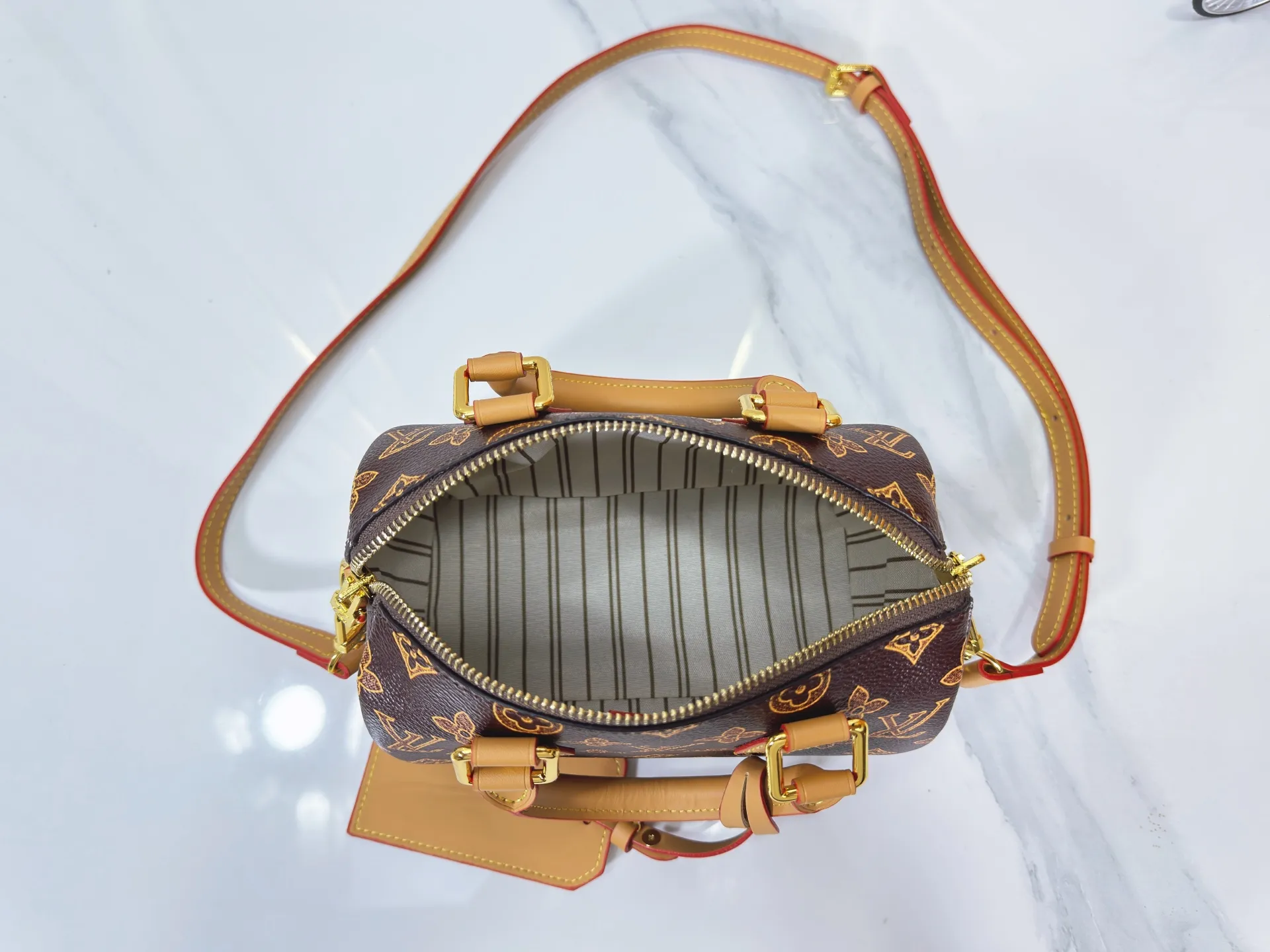 P240 M27951 M27530 Upgraded original version [Exclusive background shot] This Speedy Bandoulière 20 handbag condenses the brand's traditional Speedy travel bag design and is made of Monogram leather with fabric lining and cow leather trim. The wide, removable and adjustable fabric shoulder strap features Louis Vuitton's signature texture, and the rolled leather handles add to the carrying options. 20.5 x 13.5 x 12.0 cm (L x H x W) • Monogram coated canvas • Cow leather trim • Textile lining • Metal hardware • Padlock • Internal slip pocket • Shoulder strap: removable, adjustable • Strap half length: 39.0 cm • Strap half length adjustable to: 58.0 cm • Handle: Double handle