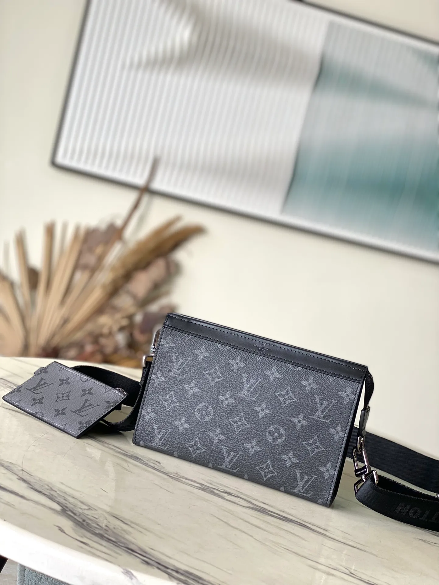 💰700 Top Original M81124 Black Flower Gaston Wearable Wallet handbag is derived from the Pochette Voyage clutch. It is cut into a suitable size with Monogram Shadow leather and can accommodate mobile phones and other travel needs. The removable and adjustable shoulder strap features a removable card holder, ideal for holding contactless payment devices or transit cards. Dimensions: 22 x 14.5 x 4.5 cm