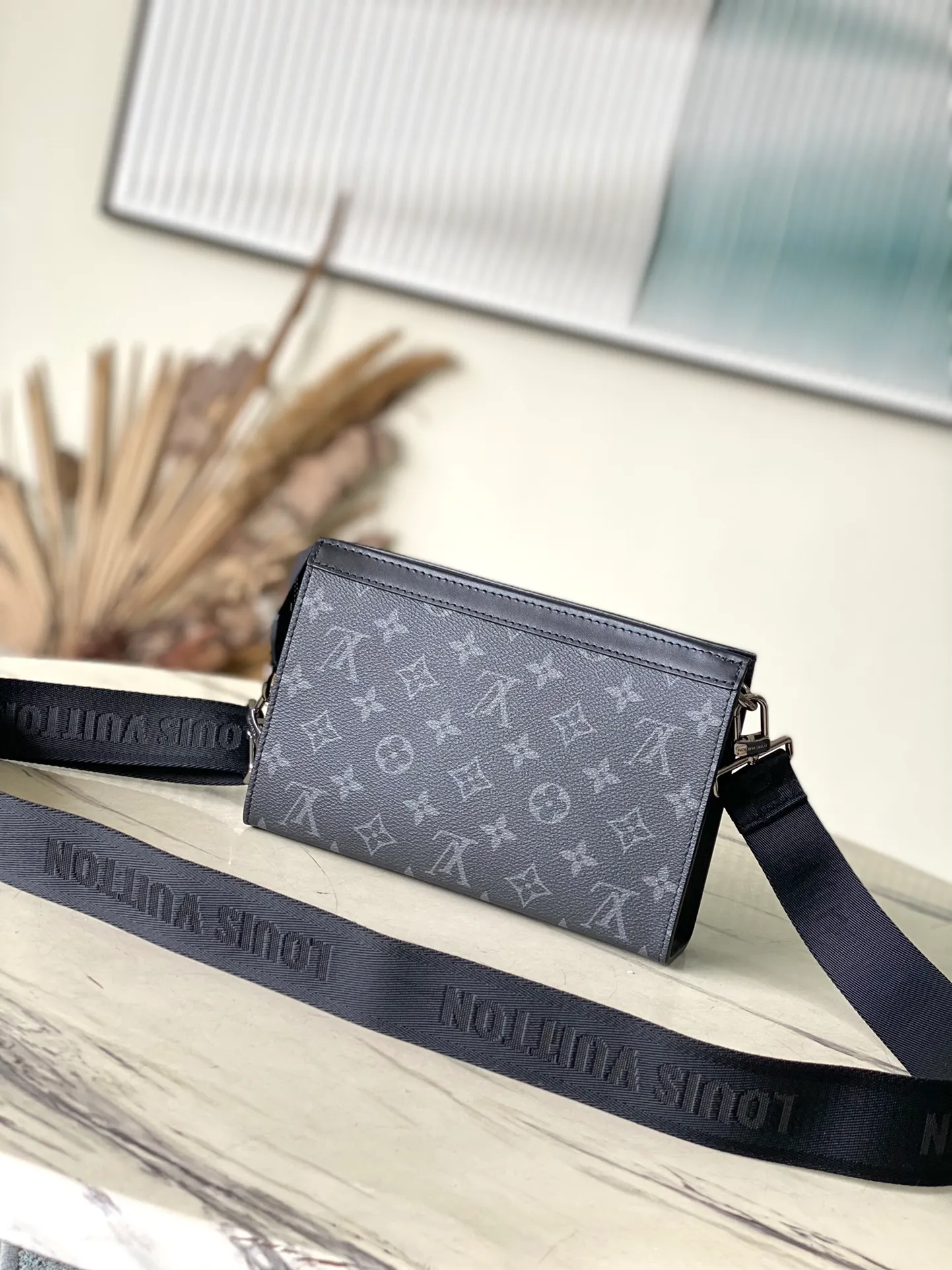 💰700 Top Original M81124 Black Flower Gaston Wearable Wallet handbag is derived from the Pochette Voyage clutch. It is cut into a suitable size with Monogram Shadow leather and can accommodate mobile phones and other travel needs. The removable and adjustable shoulder strap features a removable card holder, ideal for holding contactless payment devices or transit cards. Dimensions: 22 x 14.5 x 4.5 cm