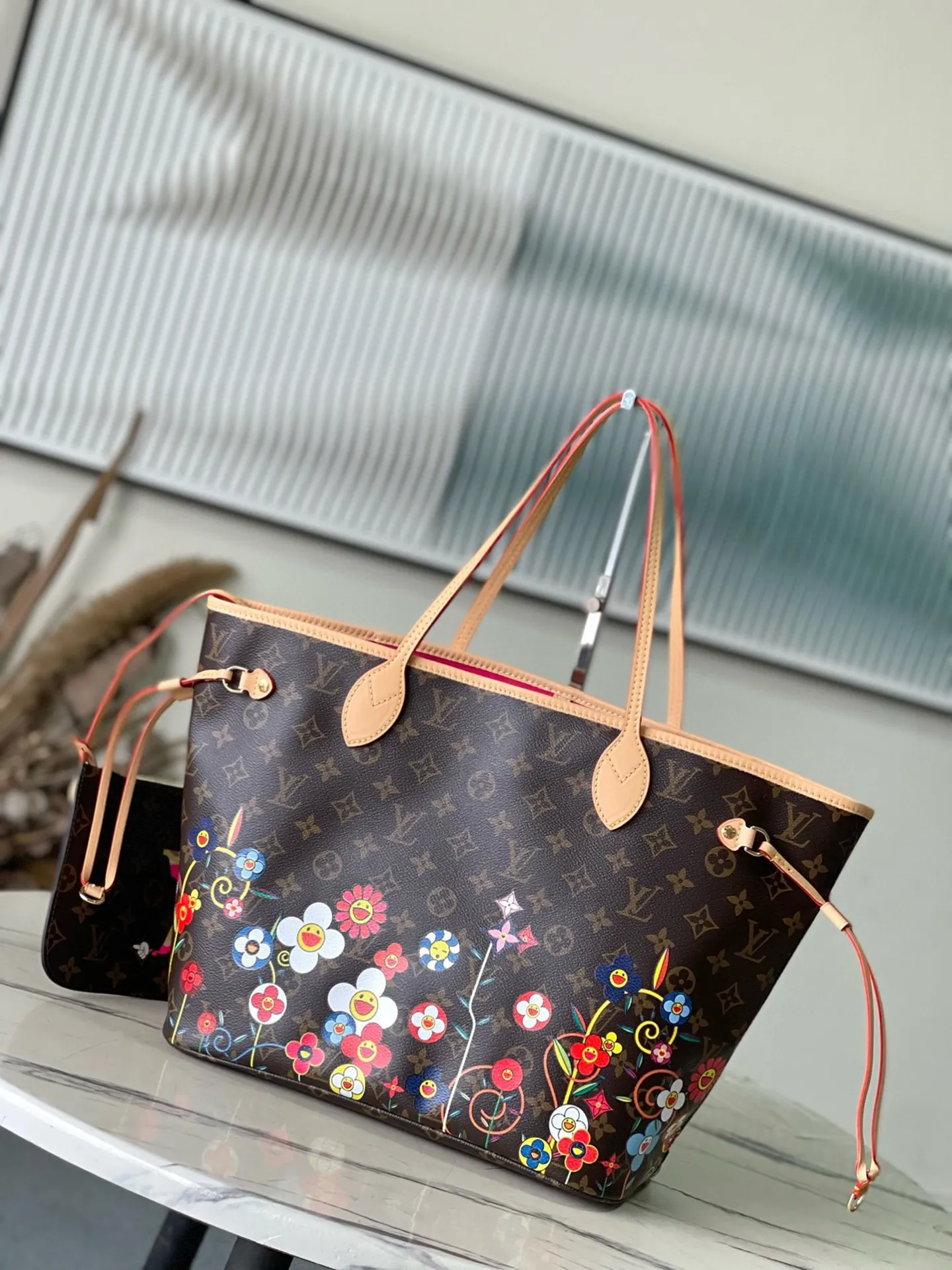 💰940 Top Original Order M13271 This medium-sized Neverfull handbag is from the Louis Vuitton x Takashi Murakami reissue series. It uses Monogram canvas to create a spacious configuration, and then uses the smart Monogram floral pattern to interpret the artist's "super flat" aesthetic style. Cowhide leather outlines the upper edge, handles and side straps, while the fabric lining incorporates colorful stripes. An interior zip pocket and a removable storage bag complete the functional design. Dimensions: 31 × 28 × 14 cm