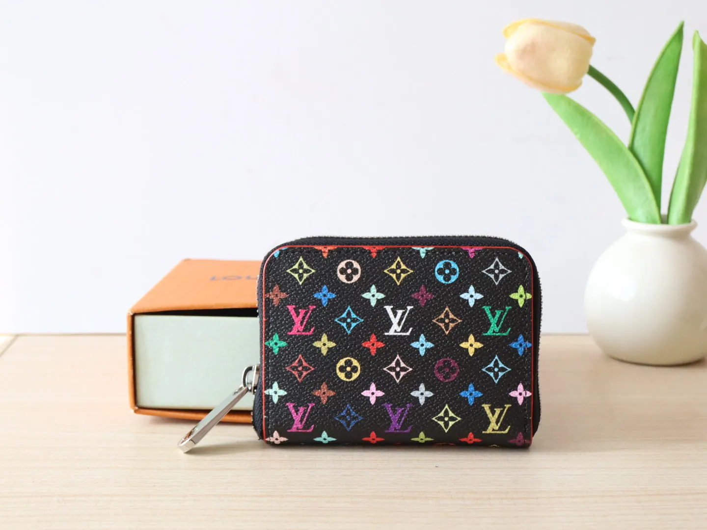 13409 Tricolor Short Zipper Style 🌟P88 LV x TM Zippy Coin Purse M13409 White Color (Tricolor - Murakami) As part of the Louis Vuitton x Murakami series reissue, the timeless Zippy coin purse is practical and playful, upgraded for this season. It's made from Monogram coated canvas in a cheerful rainbow of hues, in keeping with the Japanese artist's signature pop palette. The interior is secured with a silver zipper and is divided into multiple compartments for coins, banknotes and cards. Dimensions: 11 x 8.5 x 2 cm.