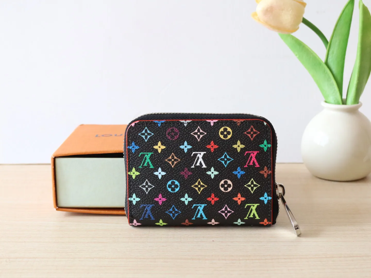 13409 Tricolor Short Zipper Style 🌟P88 LV x TM Zippy Coin Purse M13409 White Color (Tricolor - Murakami) As part of the Louis Vuitton x Murakami series reissue, the timeless Zippy coin purse is practical and playful, upgraded for this season. It's made from Monogram coated canvas in a cheerful rainbow of hues, in keeping with the Japanese artist's signature pop palette. The interior is secured with a silver zipper and is divided into multiple compartments for coins, banknotes and cards. Dimensions: 11 x 8.5 x 2 cm.