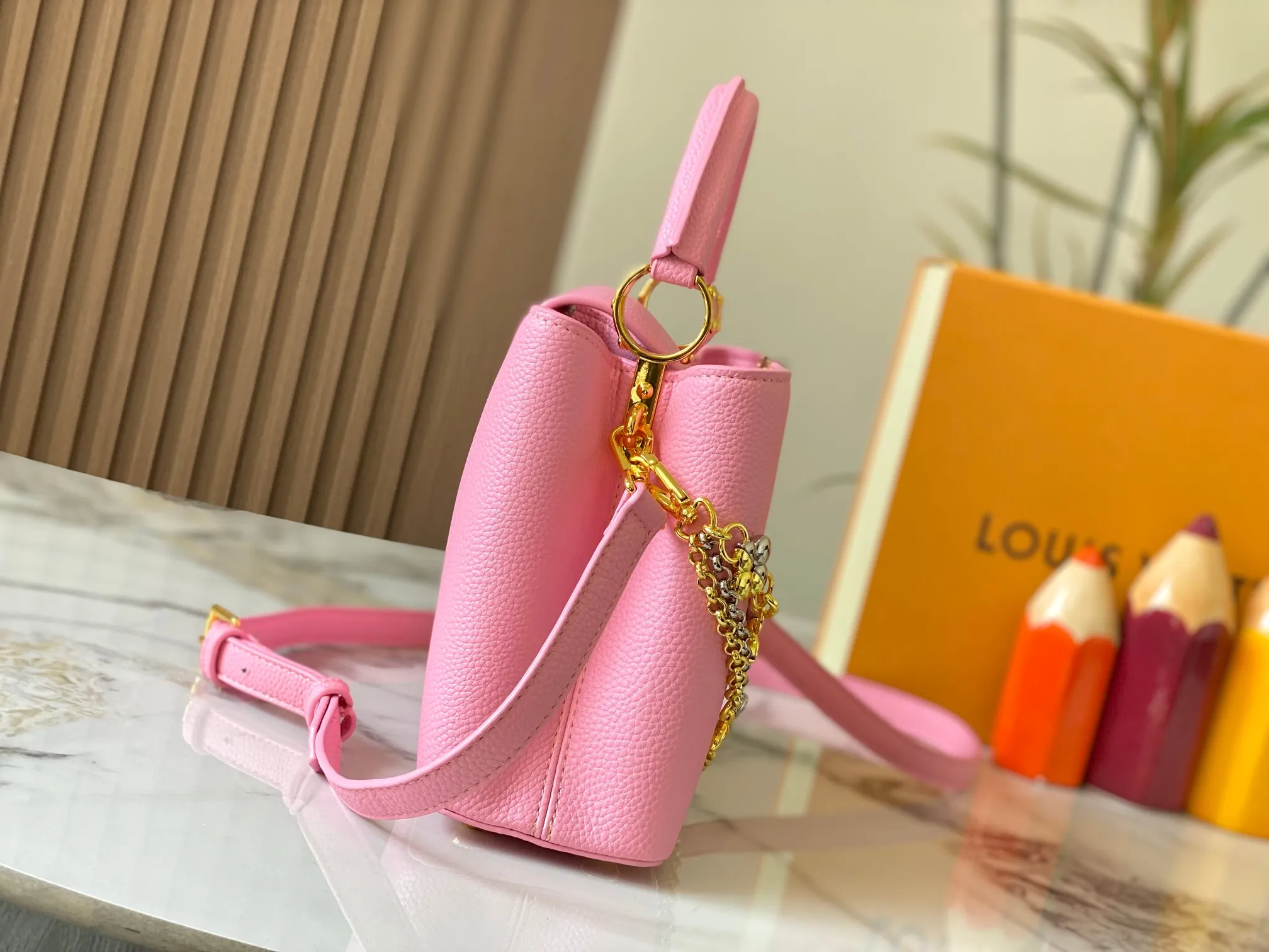 P500 [Guangzhou top quality original version] M26532 Pink This modern version of Capucines BB is made of timeless Taurillon leather and equipped with a jewelry-inspired Infinity chain. The bag is decorated with double galvanized metal parts, including the iconic Monogram floral pattern, and the LV Initials logo created with sunburst technology, creating a sundial-like light and shadow effect. The bag has multiple pockets and a detachable shoulder strap, allowing it to be carried on one shoulder or across the body. 27 x 17.3 x 9 (cm) (length x height x width)