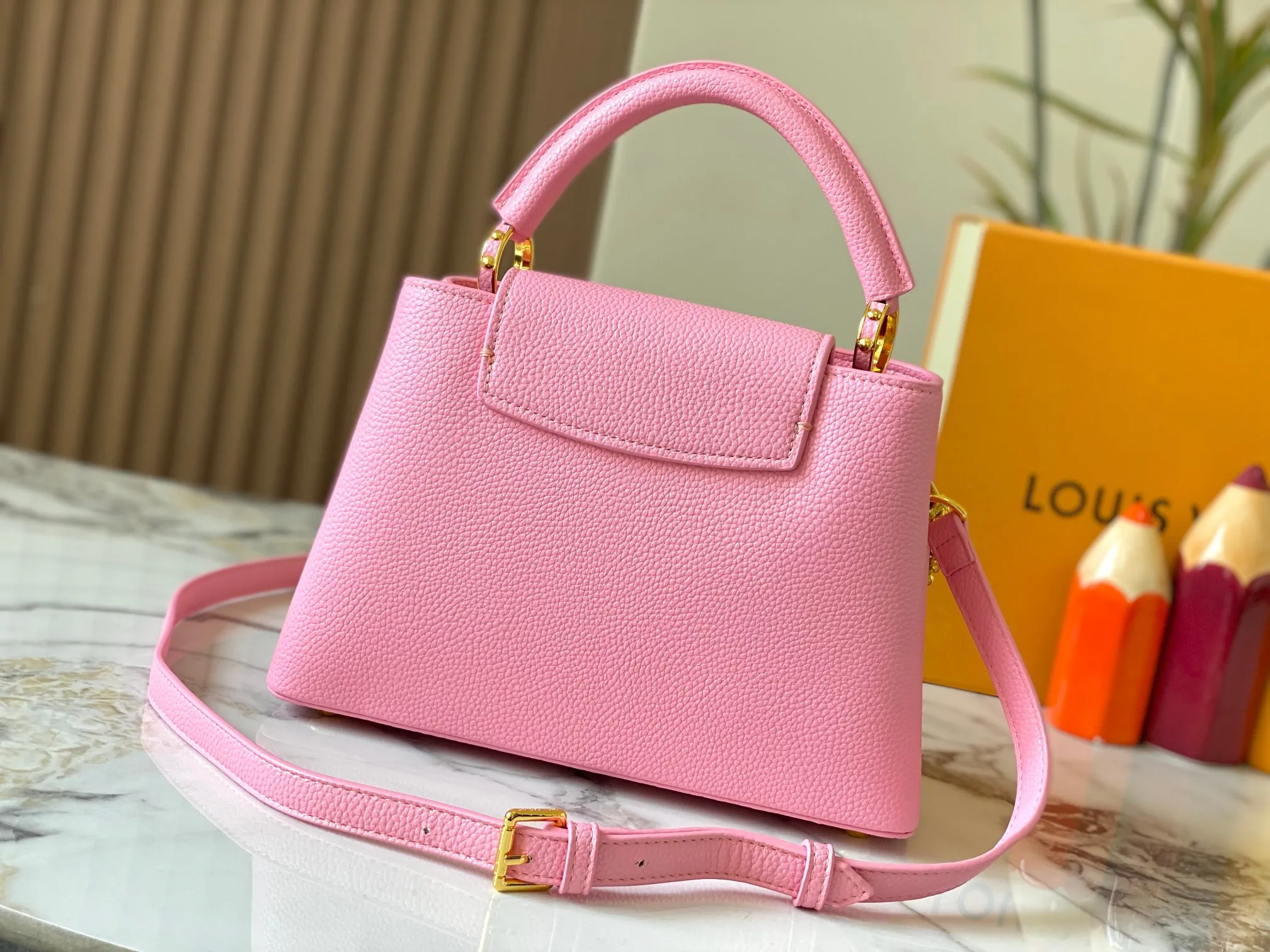 P500 [Guangzhou top quality original version] M26532 Pink This modern version of Capucines BB is made of timeless Taurillon leather and equipped with a jewelry-inspired Infinity chain. The bag is decorated with double galvanized metal parts, including the iconic Monogram floral pattern, and the LV Initials logo created with sunburst technology, creating a sundial-like light and shadow effect. The bag has multiple pockets and a detachable shoulder strap, allowing it to be carried on one shoulder or across the body. 27 x 17.3 x 9 (cm) (length x height x width)