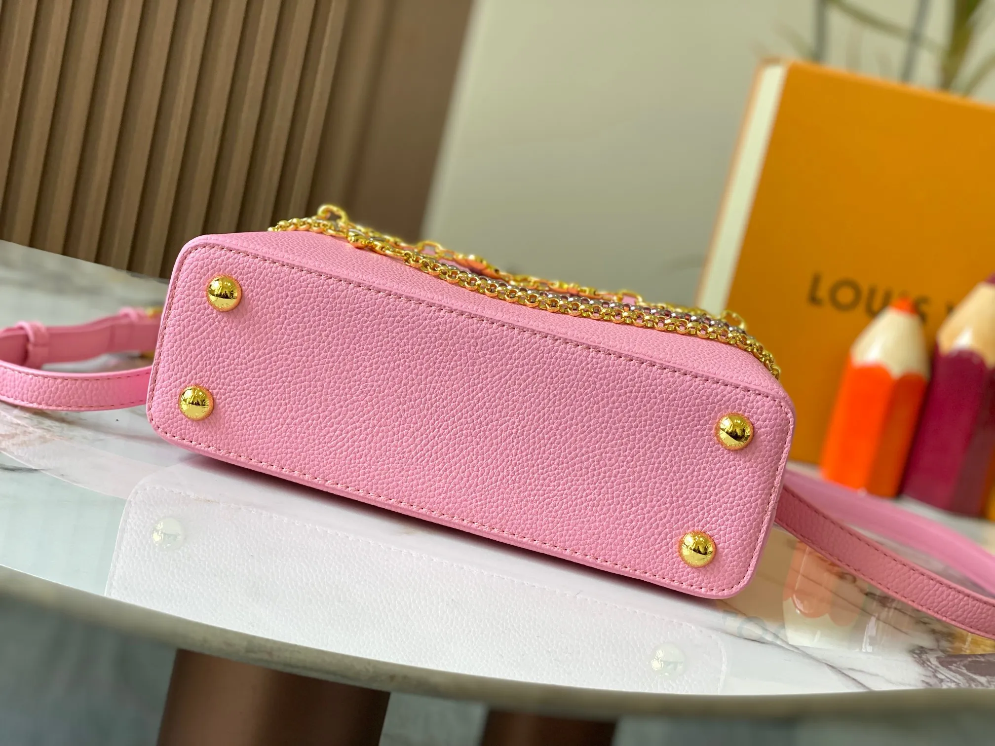 P500 [Guangzhou top quality original version] M26532 Pink This modern version of Capucines BB is made of timeless Taurillon leather and equipped with a jewelry-inspired Infinity chain. The bag is decorated with double galvanized metal parts, including the iconic Monogram floral pattern, and the LV Initials logo created with sunburst technology, creating a sundial-like light and shadow effect. The bag has multiple pockets and a detachable shoulder strap, allowing it to be carried on one shoulder or across the body. 27 x 17.3 x 9 (cm) (length x height x width)