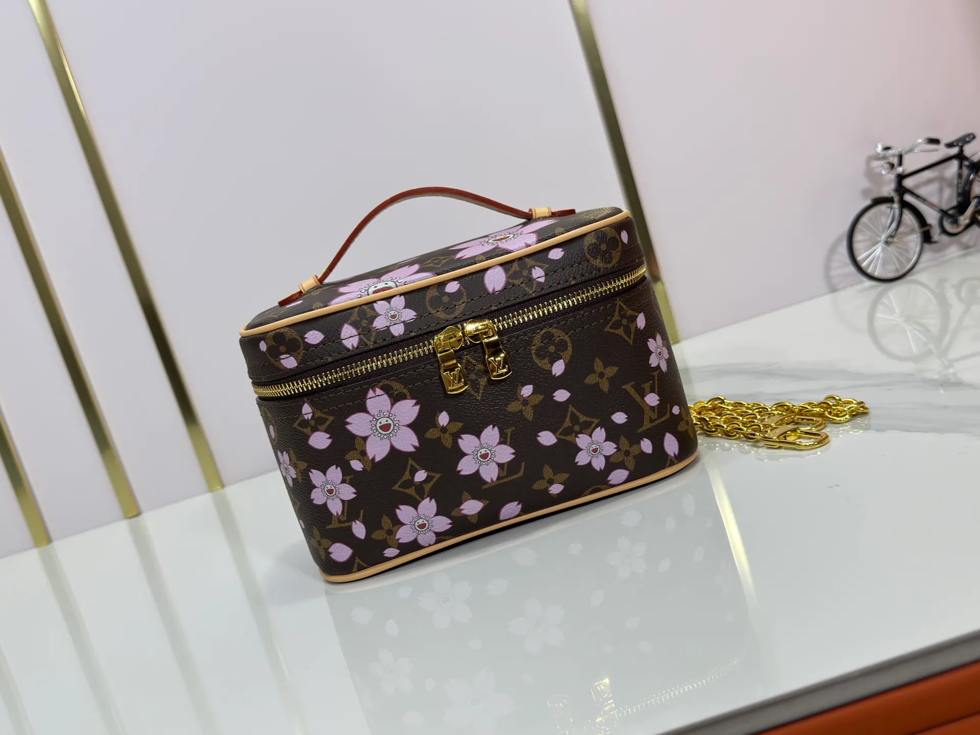 P240 Upgraded original M14181 M44495 This Nice mini cosmetic bag is made of Monogram coated canvas. The box-shaped outline is condensed with rounded strokes. The Cherry Blossom pattern releases the joyful atmosphere of the Louis Vuitton