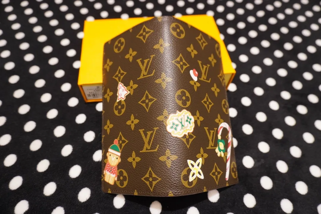 P150 62665, model number 12205 This LV Charms card holder is from the SnowShow series, incorporating smooth leather trim and festive graphics into the iconic Monogram canvas. The brand mascot Vivienne’s pet dog Petula lives in a corner, and Vivienne decorations and LV flowers complete the exquisite design. Dimensions 19x10x2