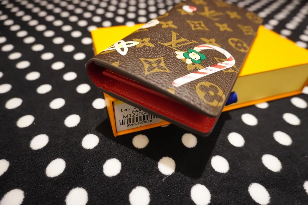 P150 62665, model number 12205 This LV Charms card holder is from the SnowShow series, incorporating smooth leather trim and festive graphics into the iconic Monogram canvas. The brand mascot Vivienne’s pet dog Petula lives in a corner, and Vivienne decorations and LV flowers complete the exquisite design. Dimensions 19x10x2