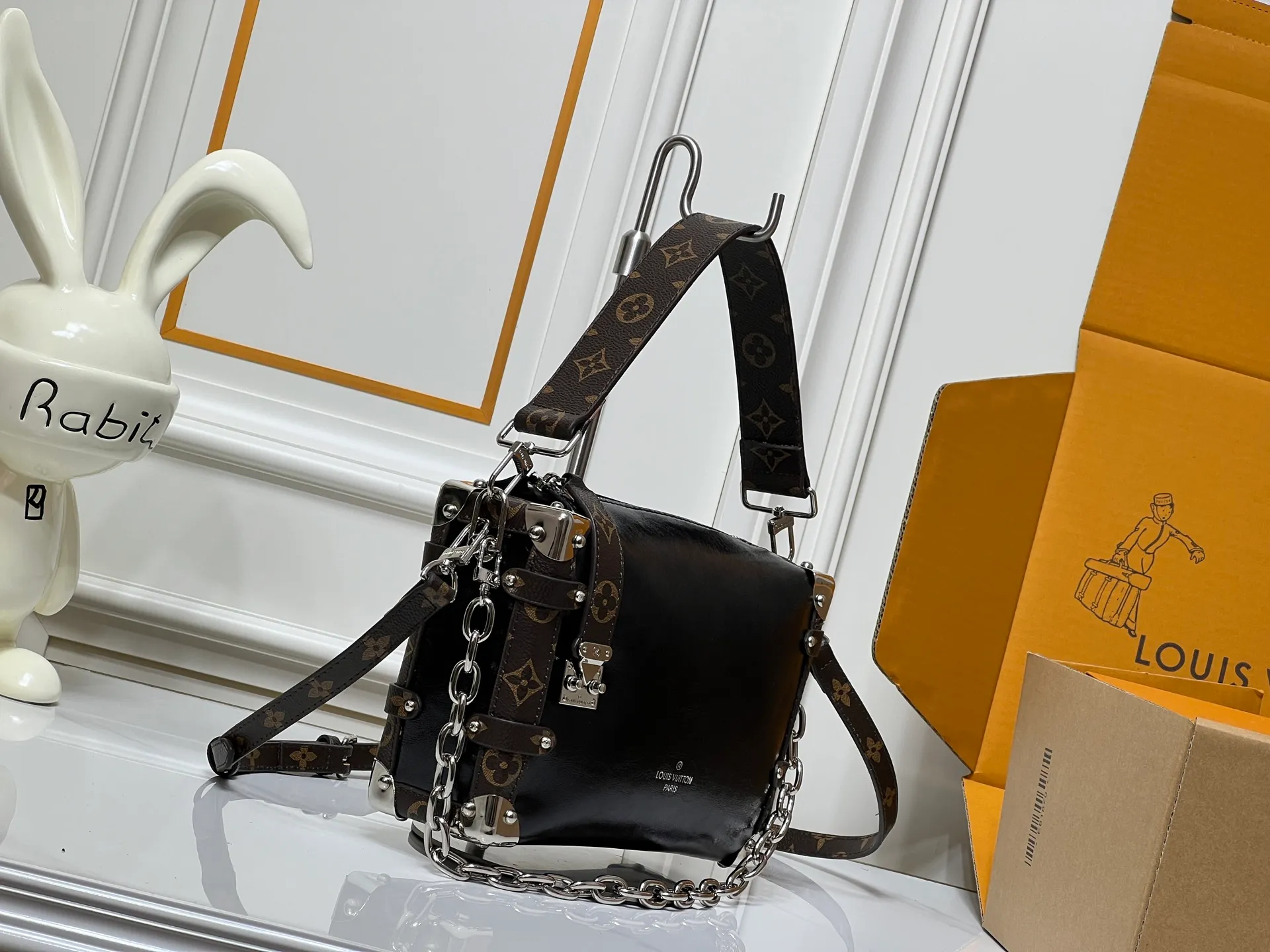 Batch 300💰M15195 M46358 This Side Trunk Vibe handbag uses an avant-garde design to reshape the brand's classic Side Trunk box silhouette, which is inspired by Louis Vuitton's traditional travel luggage. Crafted from smooth glossy Vibe textured cow leather, it features a leather-covered rivet frame and metal S-lock closure for a rock-and-roll style. Thanks to the multiple designs of the detachable chain, detachable leather handle and adjustable leather shoulder strap, it provides a variety of carrying options. Dimensions: 23.5x16x8.5cm