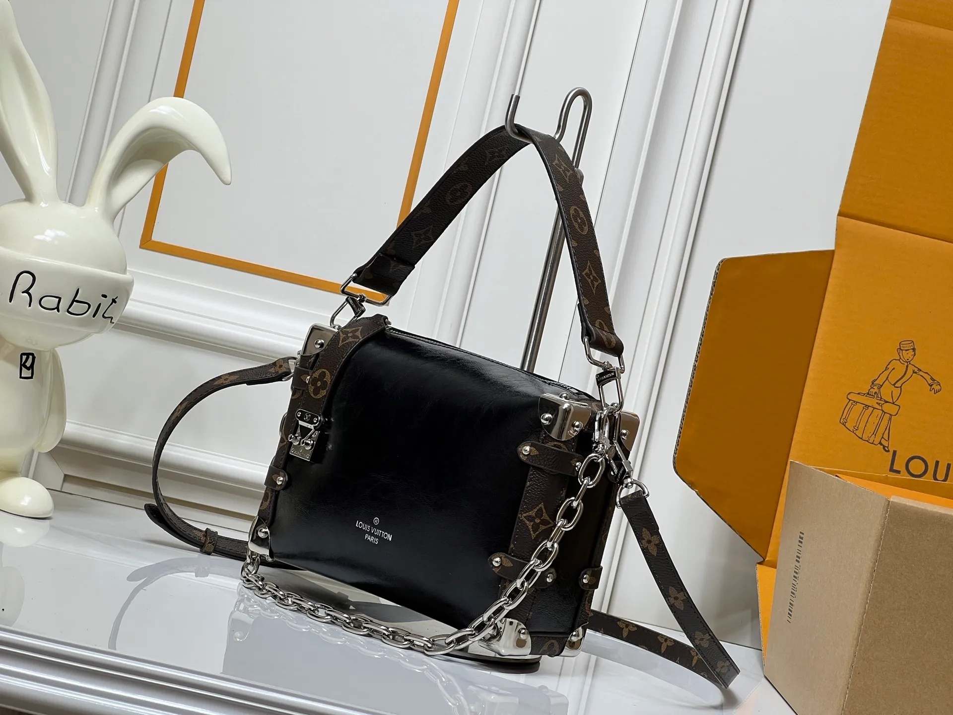 Batch 300💰M15195 M46358 This Side Trunk Vibe handbag uses an avant-garde design to reshape the brand's classic Side Trunk box silhouette, which is inspired by Louis Vuitton's traditional travel luggage. Crafted from smooth glossy Vibe textured cow leather, it features a leather-covered rivet frame and metal S-lock closure for a rock-and-roll style. Thanks to the multiple designs of the detachable chain, detachable leather handle and adjustable leather shoulder strap, it provides a variety of carrying options. Dimensions: 23.5x16x8.5cm