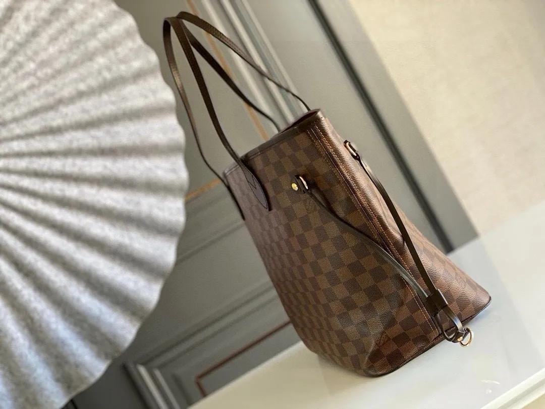 💰760 (Medium Steel Nail) Top Original N41358 NEVERFULL Medium Handbag The legendary Neverfull handbag can always meet your various needs for handbags. It has a large capacity but is not bulky. It is stiff and soft to the touch, making it suitable for home and travel. Tighten the side ties and it instantly transforms into a stylish urban handbag. Loosen the straps and it transforms into a chic and practical handbag. The slender leather handle can be carried over the shoulder or between the arms. The model shown here is made of Damier Ebène canvas.  Detailed Features 31 x 28 x 14 cm (Length x Height x Width) Bag interior redesigned with vintage details inspired by the Louis Vuitton archives - Fabric-lined interior pocket Removable zip clutch with matching interior Natural cowhide leather trim Shiny gold-tone brass hardware Handles: Double handle
