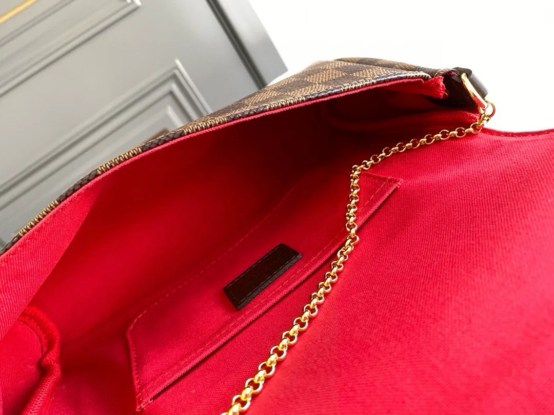 💰640 Top original item N41129 FAVORITE MM This Favorite MM handbag is the darling of fashionable women. It is sewn with geometric-style Damier Ebene canvas and is suitable for morning and evening occasions. The bag can be used as a clutch, or can be carried as a short shoulder bag using the gold chain strap, while the leather shoulder strap can be easily carried cross-body. An engraved metal plaque on the front conceals a clever magnetic closure for safe access. Details 26 x 15 x 4 cm (Length x Height x Width) Damier Ebene coated canvas Natural cowhide leather trim Textile lining Gold-tone hardware Magnetic flap closure Internal patch pocket Shoulder strap: Non-detachable, not adjustable Strap vertical height: 52.0 cm Chain strap: Detachable Chain strap vertical height: 17.0 cm