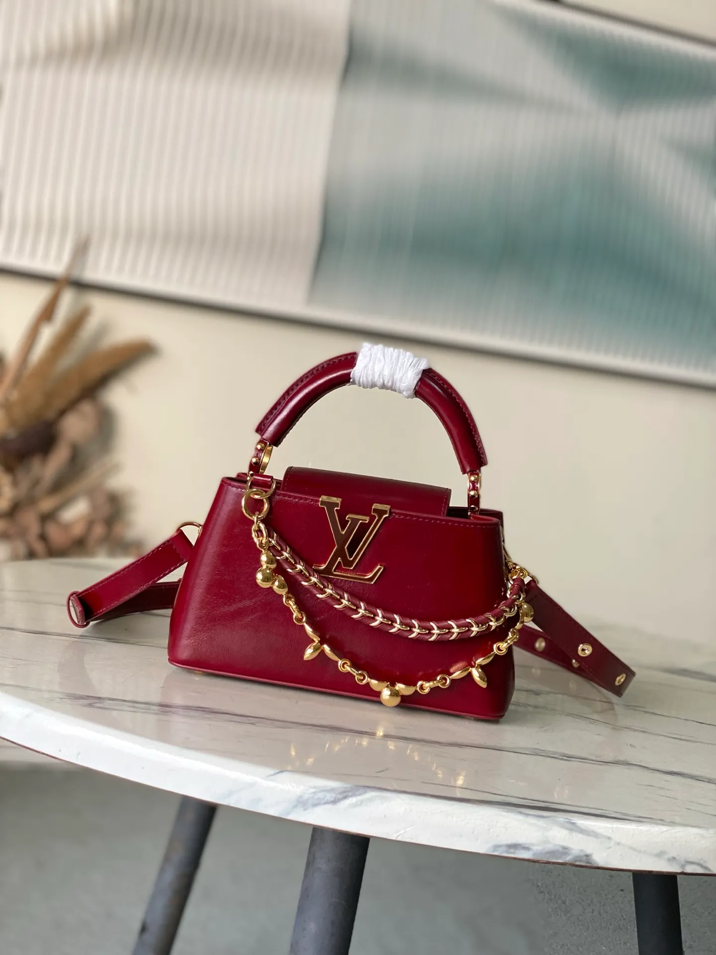 💰2160 "Special Grade Original Leather" M25473 Burgundy Oil Wax Leather Mini This Capucines East-West mini handbag gives the leather a pleated texture, telling the new season trend. The cow leather trim outlines smooth lines. The LV letters and detachable chain shimmer with metallic luster. The spacious interior meets different storage needs. A variety of carrying methods show functional ingenuity. Size: 22*12*8CM