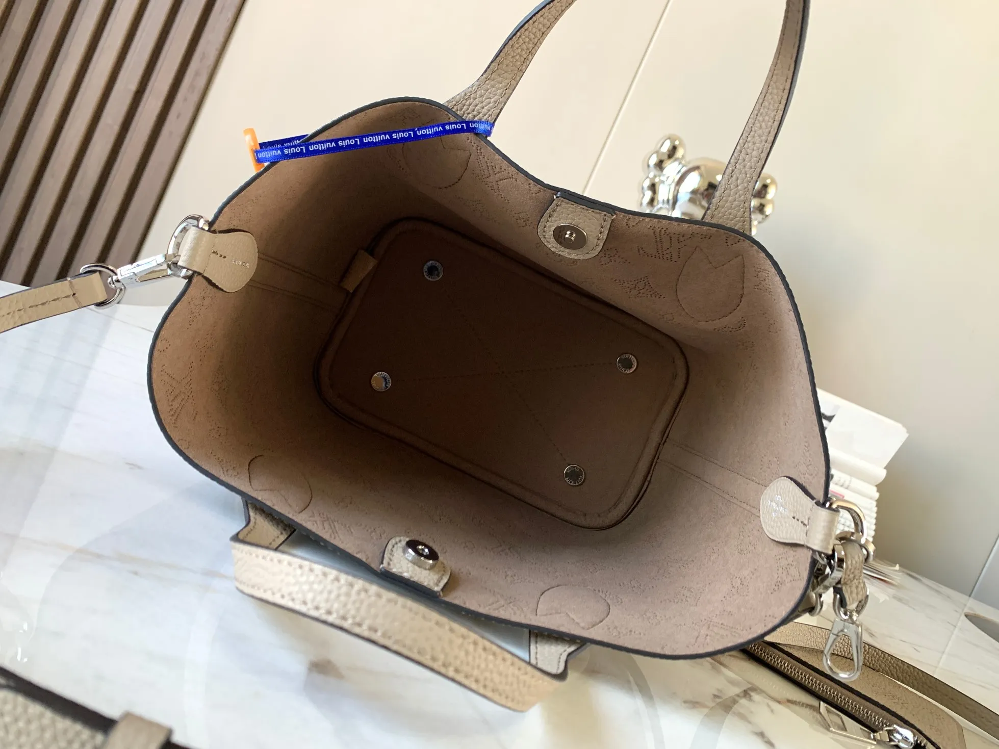 P1500【Original Leather💋M21849 Elephant Gray】This small Blossom handbag is made of engraved and perforated cow leather, which demonstrates practical functions in a leisurely style. The inner compartment is equipped with a detachable zipper bag to easily accommodate daily needs; the handle is convenient for carrying by hand or elbow, and the detachable and adjustable shoulder strap adds shoulder and cross-body options. Detailed dimensions: 20 x 20 x 12.5 cm