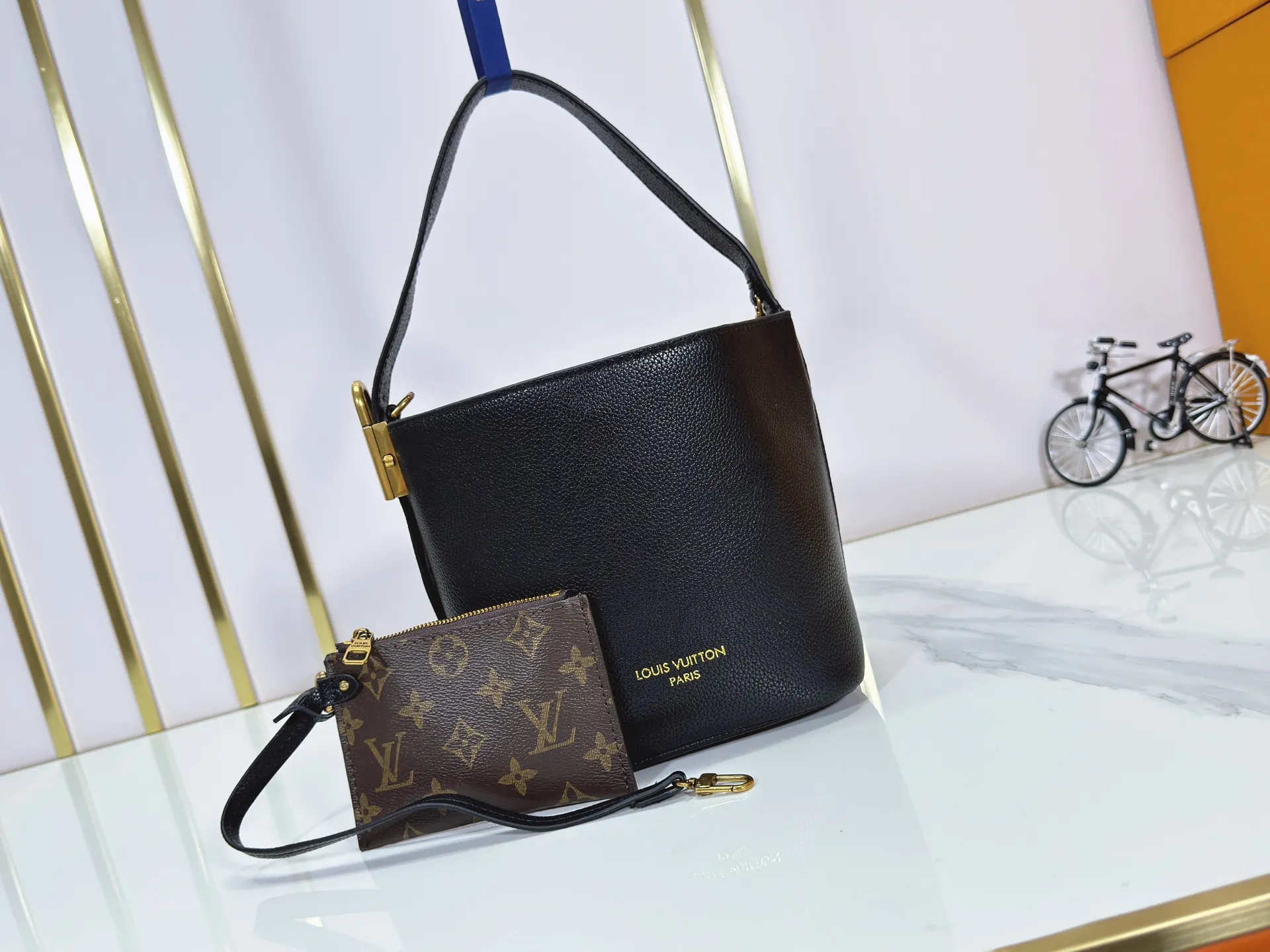 P260 Upgraded original version M25543, M14416, M12925 M25673 This All In BB handbag is from the Low Key series. It is made of grained cow leather to create a compact bucket bag configuration, which can be carried in various ways for day and night occasions. The distressed metal pieces convey a retro feel, while the padlock and detachable Monogram pocket highlight the brand's style. Size: 16*12*18cm
