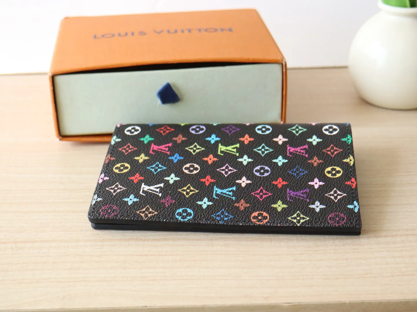 13414 Tricolor Passport🌟 P86 Top Original LV x TM Passport Case M13414 Black Color (White Color Black Color-Takashi Murakami) This passport cover is lined with coated canvas and cow leather, and the Monogram pattern is updated with the rainbow tones of artist Takashi Murakami, which expresses the smart style of the Louis Vuitton x Murakami collaboration series. Card compartments and multiple pockets add functional details. Dimensions: 14 x 2.5 x 10 cm