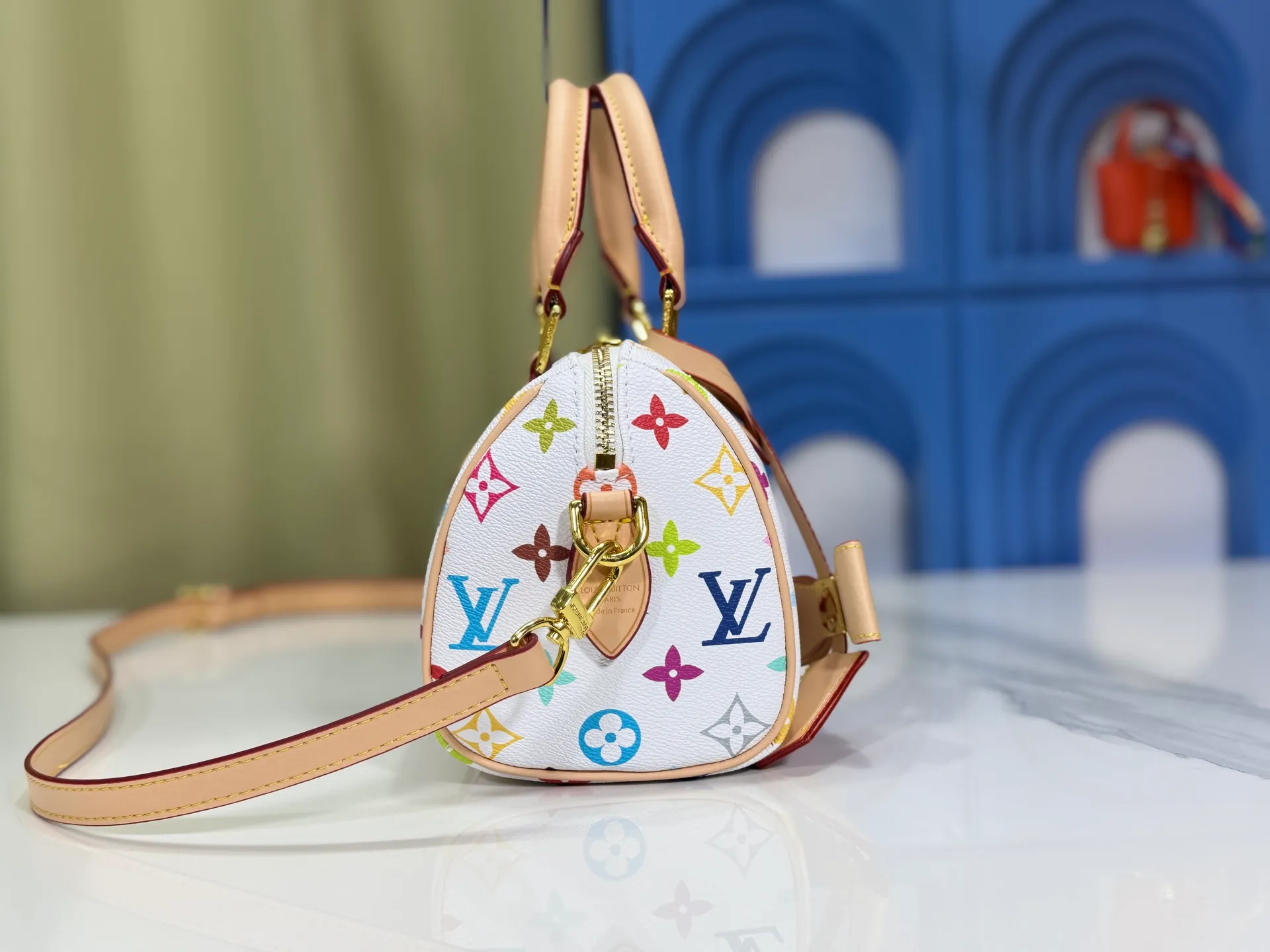 P260 Upgraded from the original version, this M46234 M46222 Speedy Bandoulière 20 handbag is made of soft coated canvas, with the full-length Monogram pattern traced in colorful rainbow tones, highlighting the smart style of the Louis Vuitton x Murakami reissue series. The Toron handle and detachable shoulder strap are constructed of cow leather, the metal corners recall classic luggage elements, and the bow-shaped key bag and padlock add brand touches. Dimensions: 20.5 x 13.5 x 12.0 cm (length x height x width)