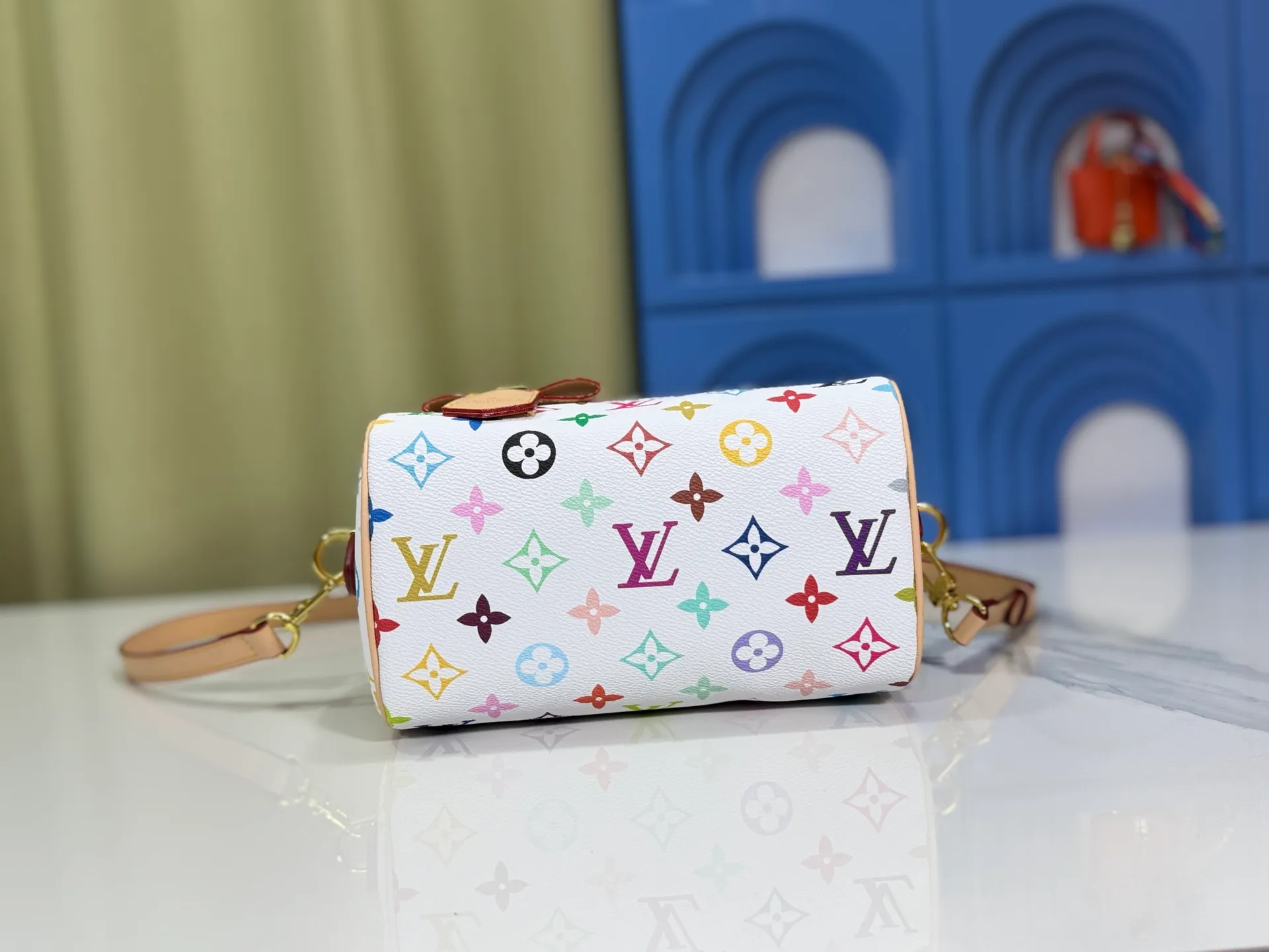 P260 Upgraded from the original version, this M46234 M46222 Speedy Bandoulière 20 handbag is made of soft coated canvas, with the full-length Monogram pattern traced in colorful rainbow tones, highlighting the smart style of the Louis Vuitton x Murakami reissue series. The Toron handle and detachable shoulder strap are constructed of cow leather, the metal corners recall classic luggage elements, and the bow-shaped key bag and padlock add brand touches. Dimensions: 20.5 x 13.5 x 12.0 cm (length x height x width)