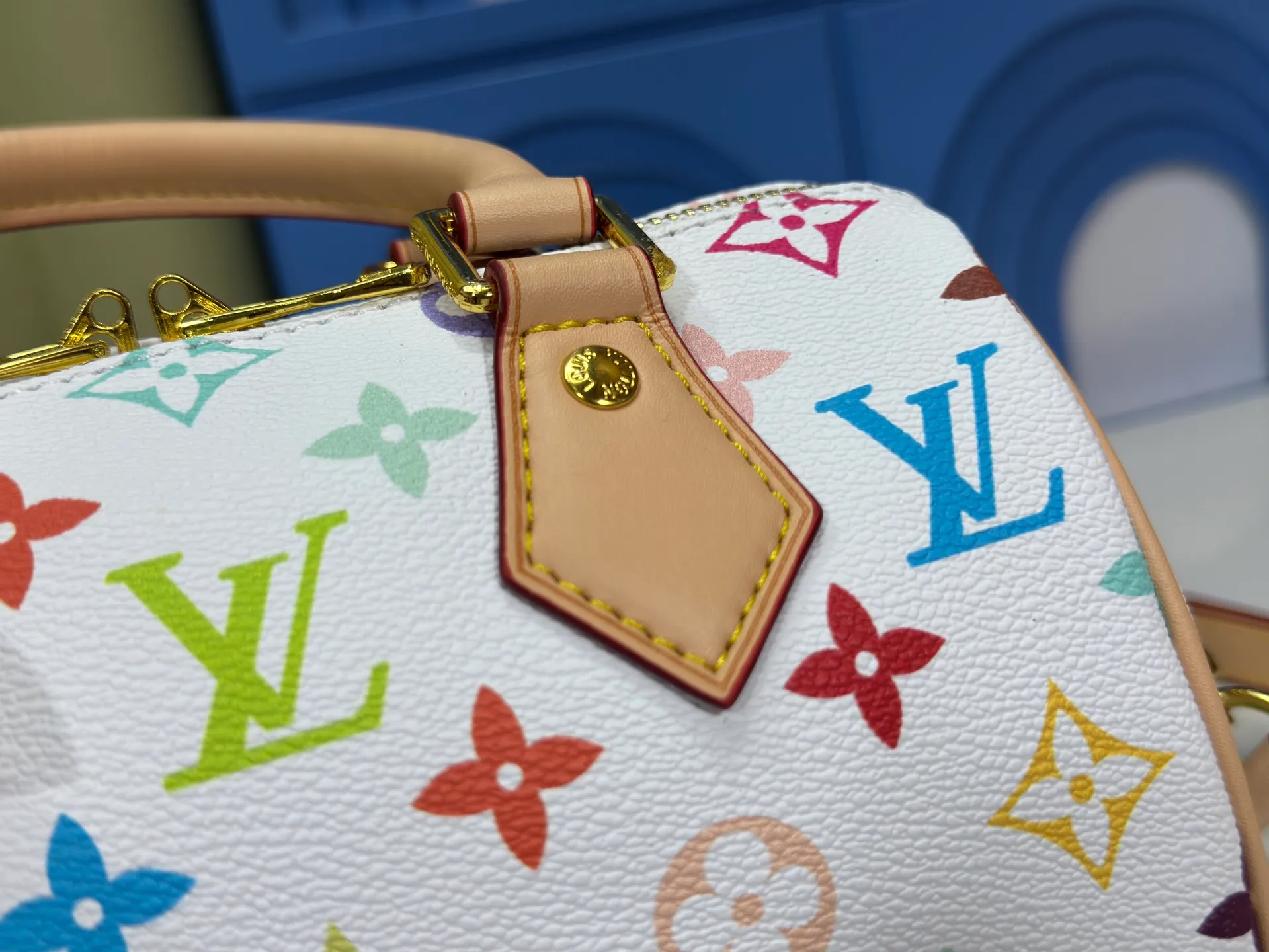 P260 Upgraded from the original version, this M46234 M46222 Speedy Bandoulière 20 handbag is made of soft coated canvas, with the full-length Monogram pattern traced in colorful rainbow tones, highlighting the smart style of the Louis Vuitton x Murakami reissue series. The Toron handle and detachable shoulder strap are constructed of cow leather, the metal corners recall classic luggage elements, and the bow-shaped key bag and padlock add brand touches. Dimensions: 20.5 x 13.5 x 12.0 cm (length x height x width)