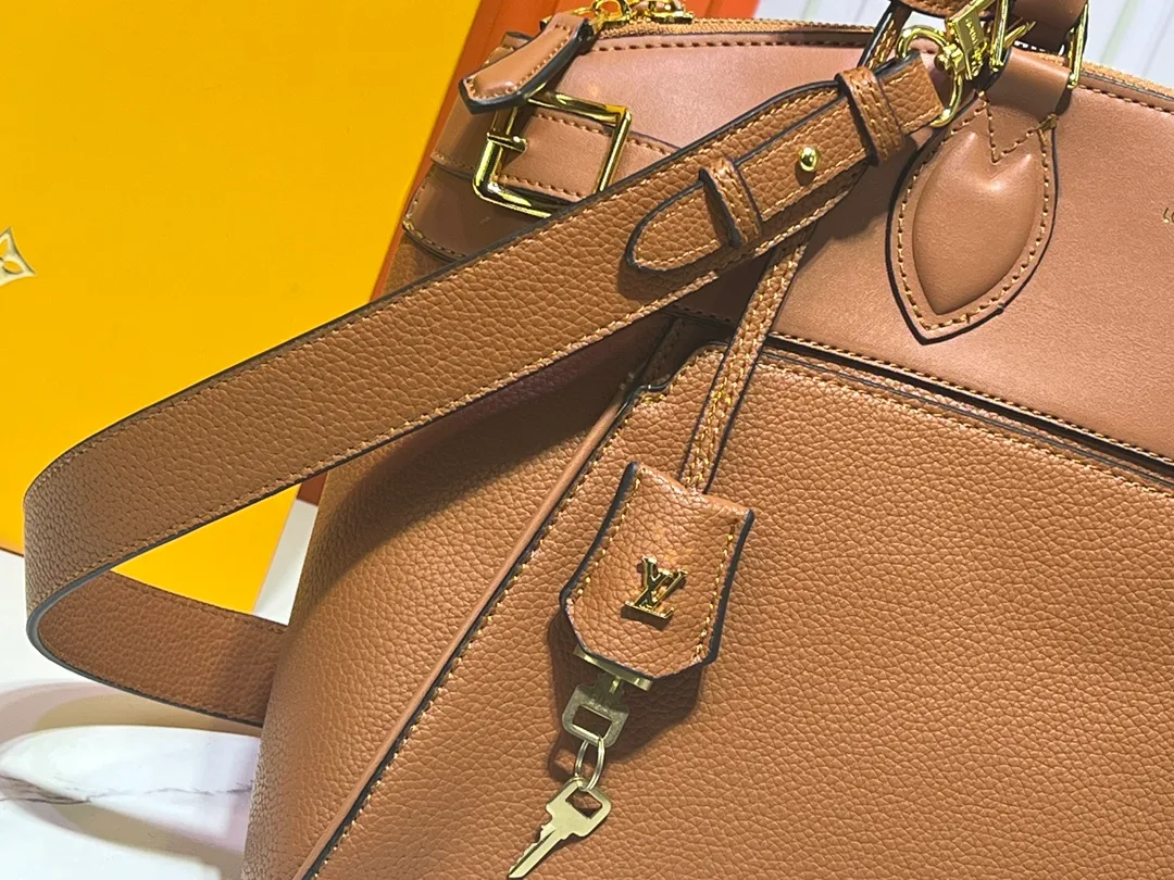 Batch 340💰M11214 green M22914 black M22925 brown M23061 off-white M22927 taupe. Sophisticated and functional, the Lock It MM bag is crafted in fine grained Taurillon leather and smooth calfskin, with gold-finish buckles and hardware. Signature House touches include padlocks, key bells and hot-stamped Louis Vuitton signatures. Featuring an articulated top handle and removable strap, this tote offers a variety of carrying options. 36x29x15 cm (LxHxW) Black Taurillon leather, smooth calfskin semi-leather trim Microfiber lining Gold hardware 2 square buckles padlock key bell External pockets 2 internal flat pockets Internal zipped pocket with flat pockets 5 protective metal studs Strap: removable, adjustable Strap drop: 45.0 cm Maximum strap drop: 51.0 cm