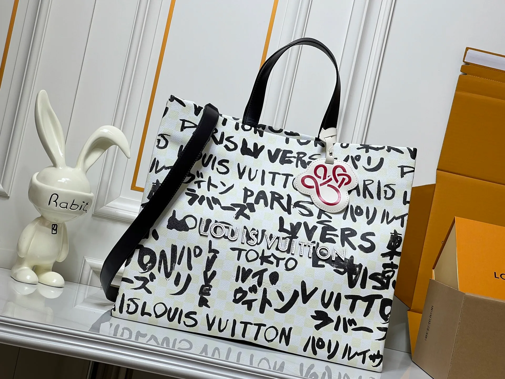 Batch 320💰M24457 M40797 This Shopper Tote medium handbag features Damier checkerboard pattern superimposed with eye-catching hand-painted elements, witnessing the joint creativity of Pharrell Williams and Japanese designer Nigo. The names Louis Vuitton, Paris and Tokyo, as well as the word Lvvers, are bilingual in French and Japanese, and the graphic cotton lining showcases Nigo's signature style. Size: 41x34x16cm