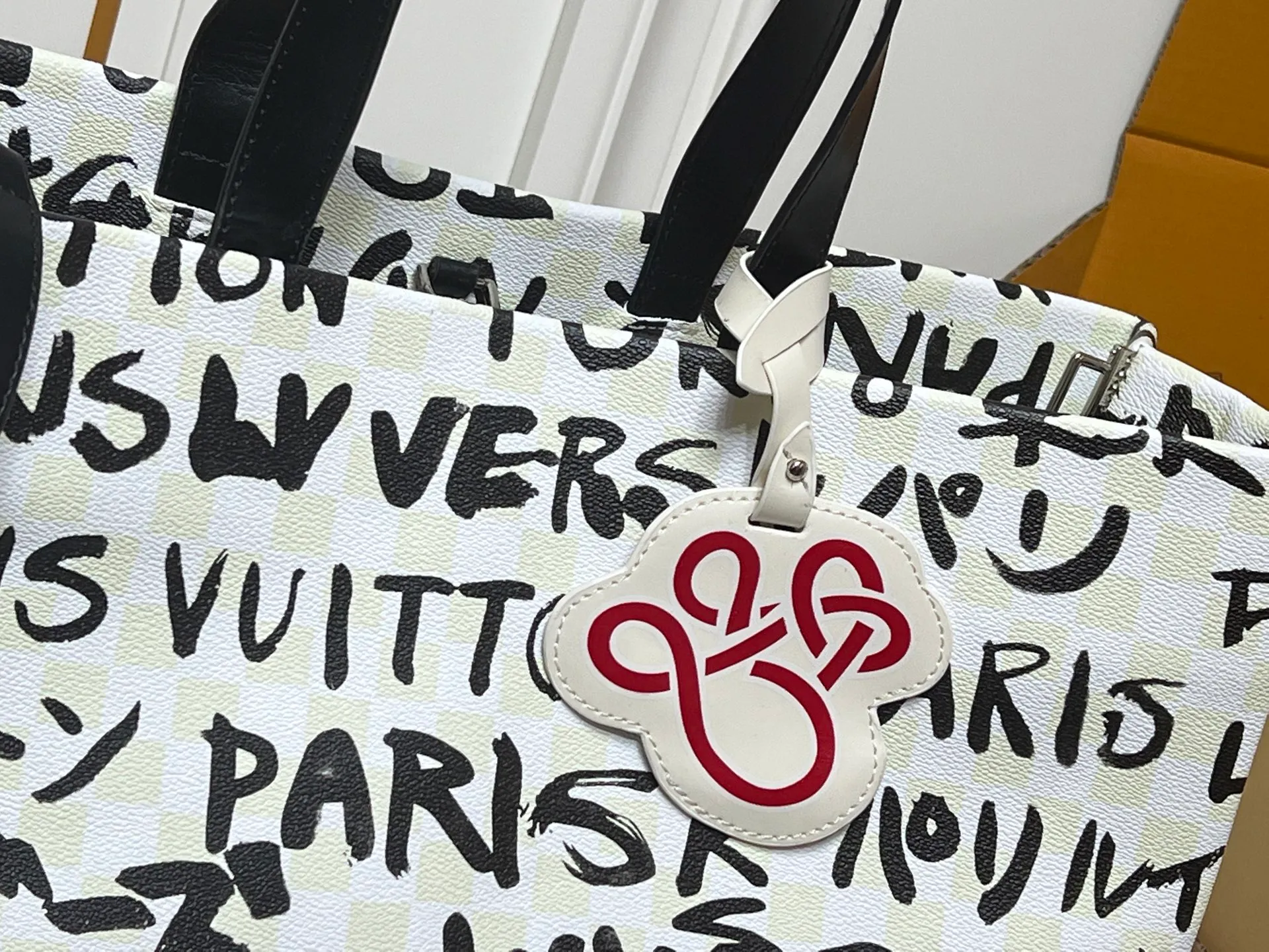 Batch 320💰M24457 M40797 This Shopper Tote medium handbag features Damier checkerboard pattern superimposed with eye-catching hand-painted elements, witnessing the joint creativity of Pharrell Williams and Japanese designer Nigo. The names Louis Vuitton, Paris and Tokyo, as well as the word Lvvers, are bilingual in French and Japanese, and the graphic cotton lining showcases Nigo's signature style. Size: 41x34x16cm