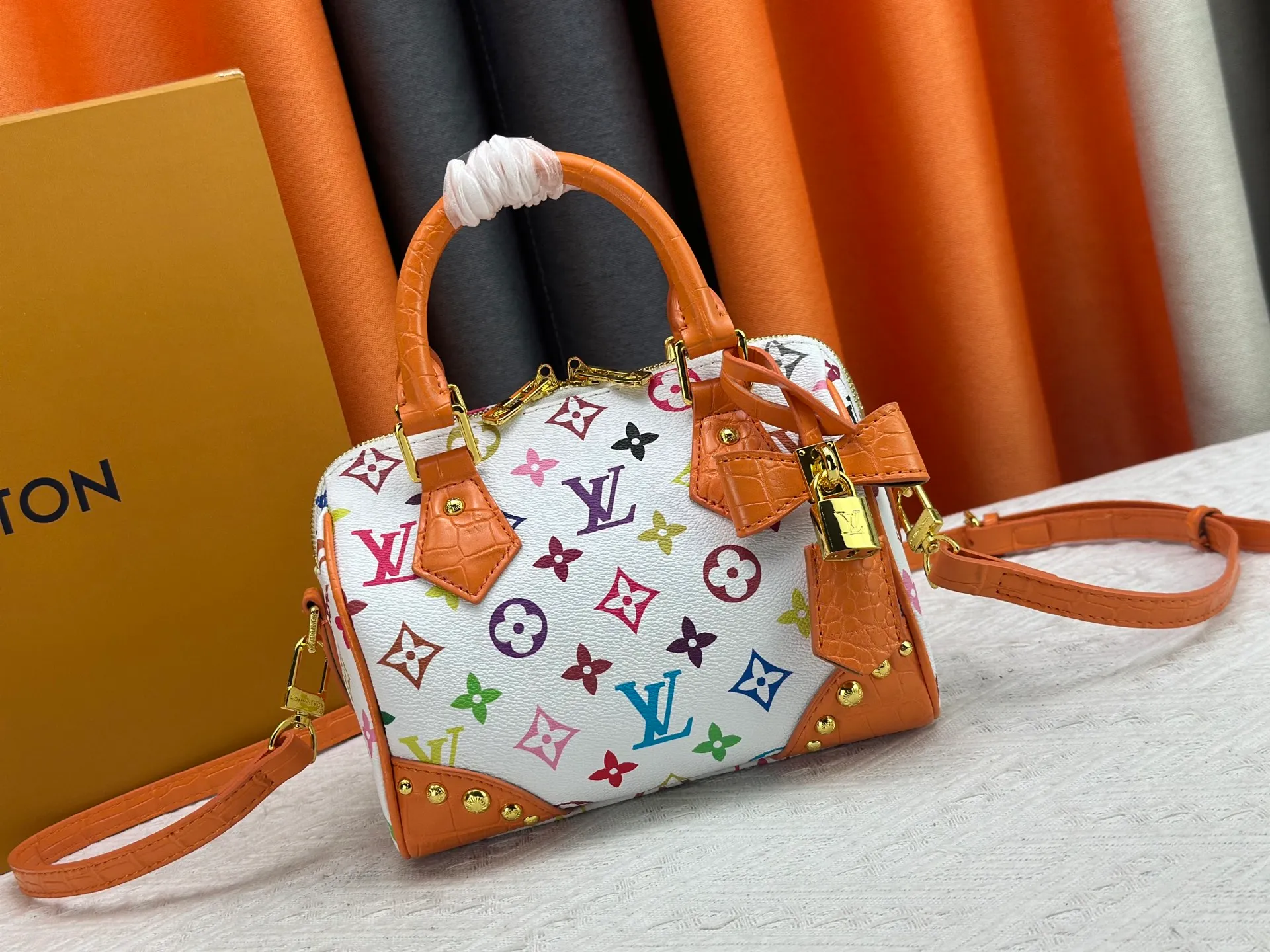 P260 Upgraded original crocodile pattern M13365 M58953 M46234 M46222 Speedy Bandoulière 20 handbag is made of soft coated canvas, and the full-length Monogram pattern is traced in colorful rainbow tones, highlighting the smart style of the Louis Vuitton x Murakami reissue series. The Toron handle and detachable shoulder strap are constructed of cow leather, the metal corners recall classic luggage elements, and the bow-shaped key bag and padlock add brand touches. Dimensions: 20.5 x 13.5 x 12.0 cm (length x height x width)