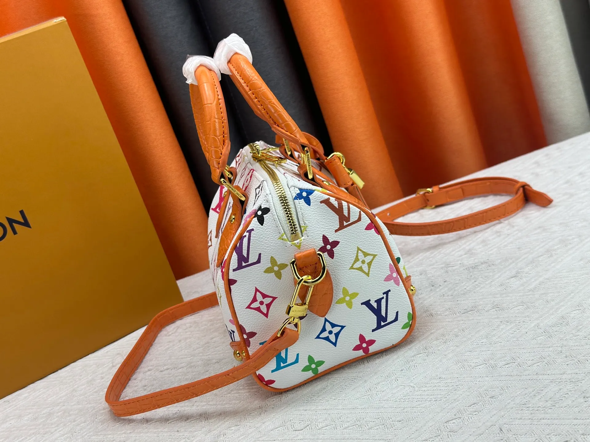 P260 Upgraded original crocodile pattern M13365 M58953 M46234 M46222 Speedy Bandoulière 20 handbag is made of soft coated canvas, and the full-length Monogram pattern is traced in colorful rainbow tones, highlighting the smart style of the Louis Vuitton x Murakami reissue series. The Toron handle and detachable shoulder strap are constructed of cow leather, the metal corners recall classic luggage elements, and the bow-shaped key bag and padlock add brand touches. Dimensions: 20.5 x 13.5 x 12.0 cm (length x height x width)