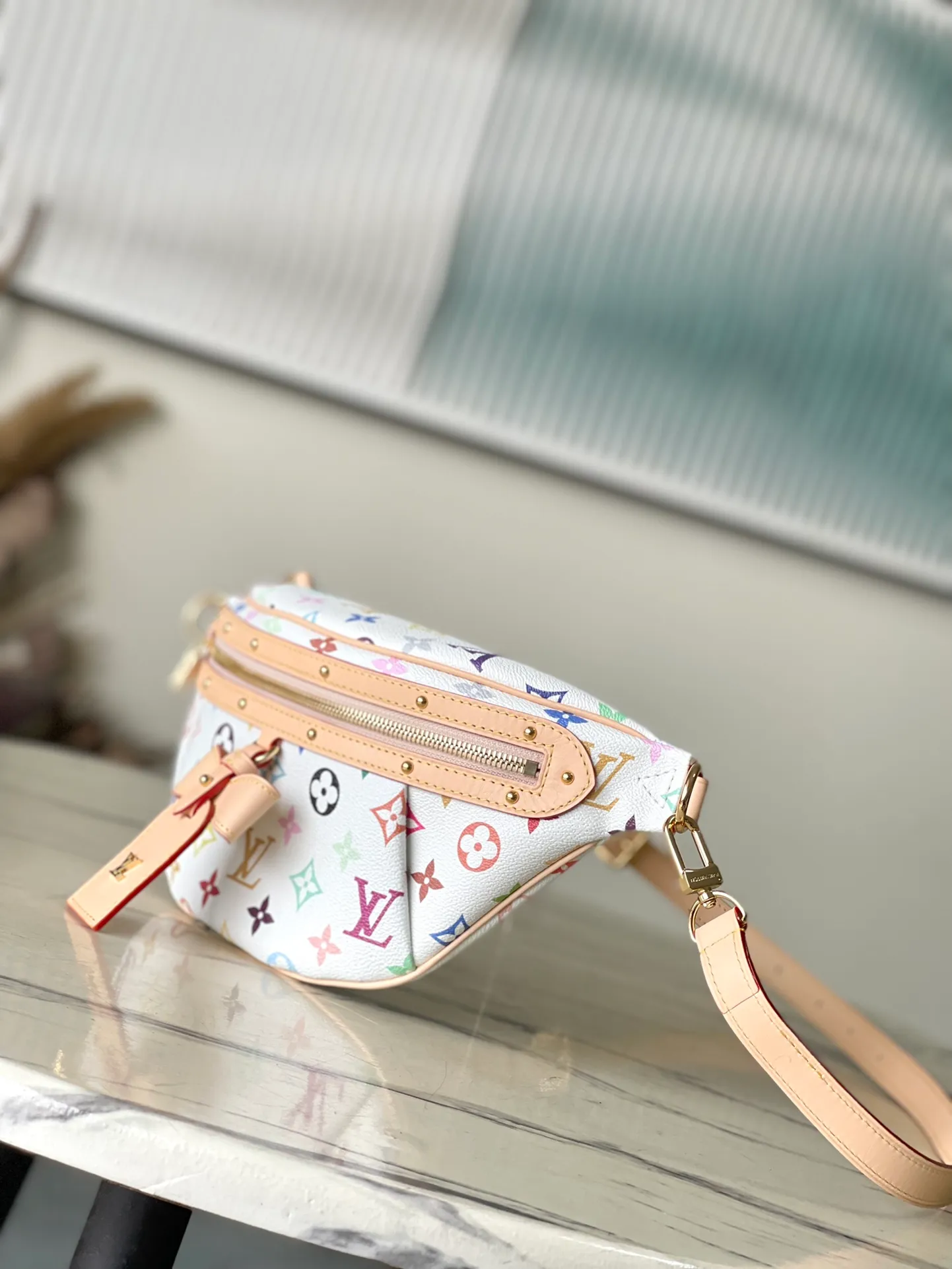 💰900 Top Original M13660 The High Rise bumbag is an iconic piece in the vibrant prints of the reissued Louis Vuitton x Murakami collection: crafted in coated canvas, the signature Monogram pattern is rendered in a rainbow of colors, referencing the Japanese artist’s signature palette of pop colors. The brand's signature natural cowhide leather highlights the front zipper and arched LV x TM name tag. Dimensions: 34.5×16×7,5cm (length x height x width)