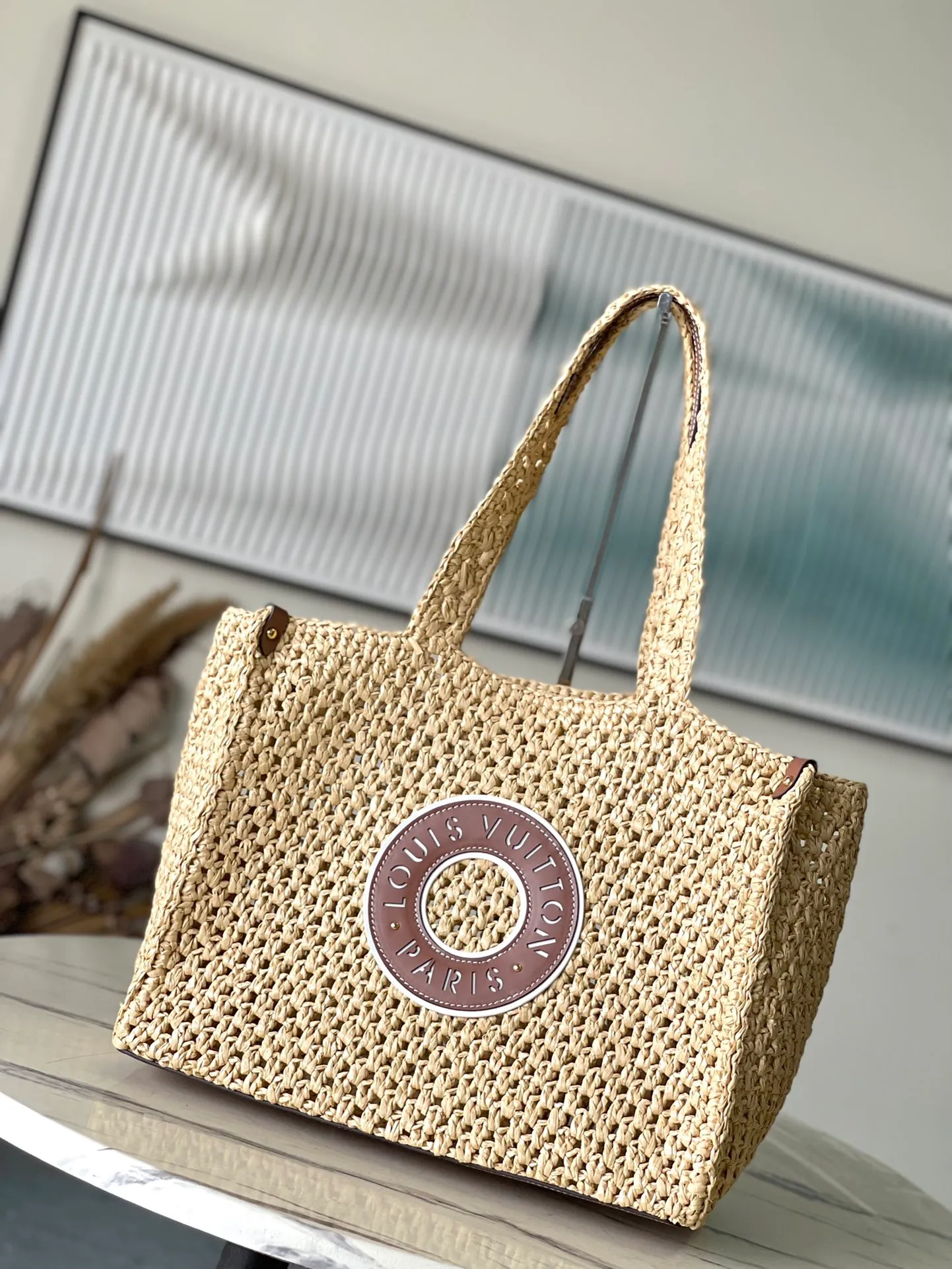 💰1580 Top Original Order M24723 This medium-sized OnTheGo handbag is from the LVBy The Pool series. It is shaped like a tote bag with crocheted raffia and can accommodate a 13-inch laptop, beach towel and other travel essentials. The studded corners are finished in calfskin and are complemented by round Paris patches. Dimensions: 37.5 × 30 × 17 cm