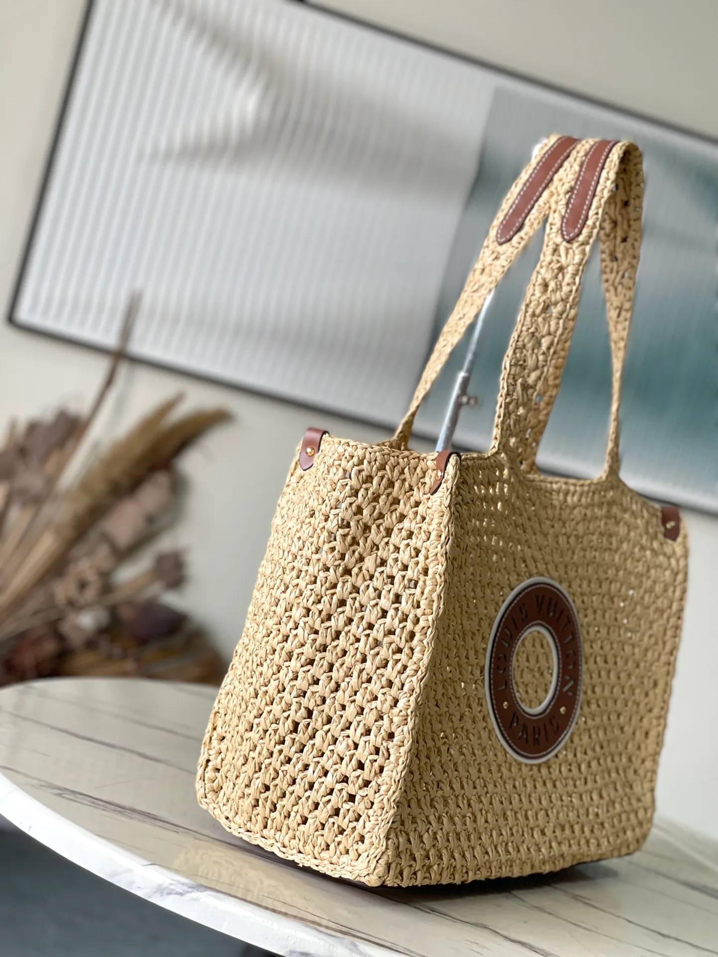 💰1580 Top Original Order M24723 This medium-sized OnTheGo handbag is from the LVBy The Pool series. It is shaped like a tote bag with crocheted raffia and can accommodate a 13-inch laptop, beach towel and other travel essentials. The studded corners are finished in calfskin and are complemented by round Paris patches. Dimensions: 37.5 × 30 × 17 cm